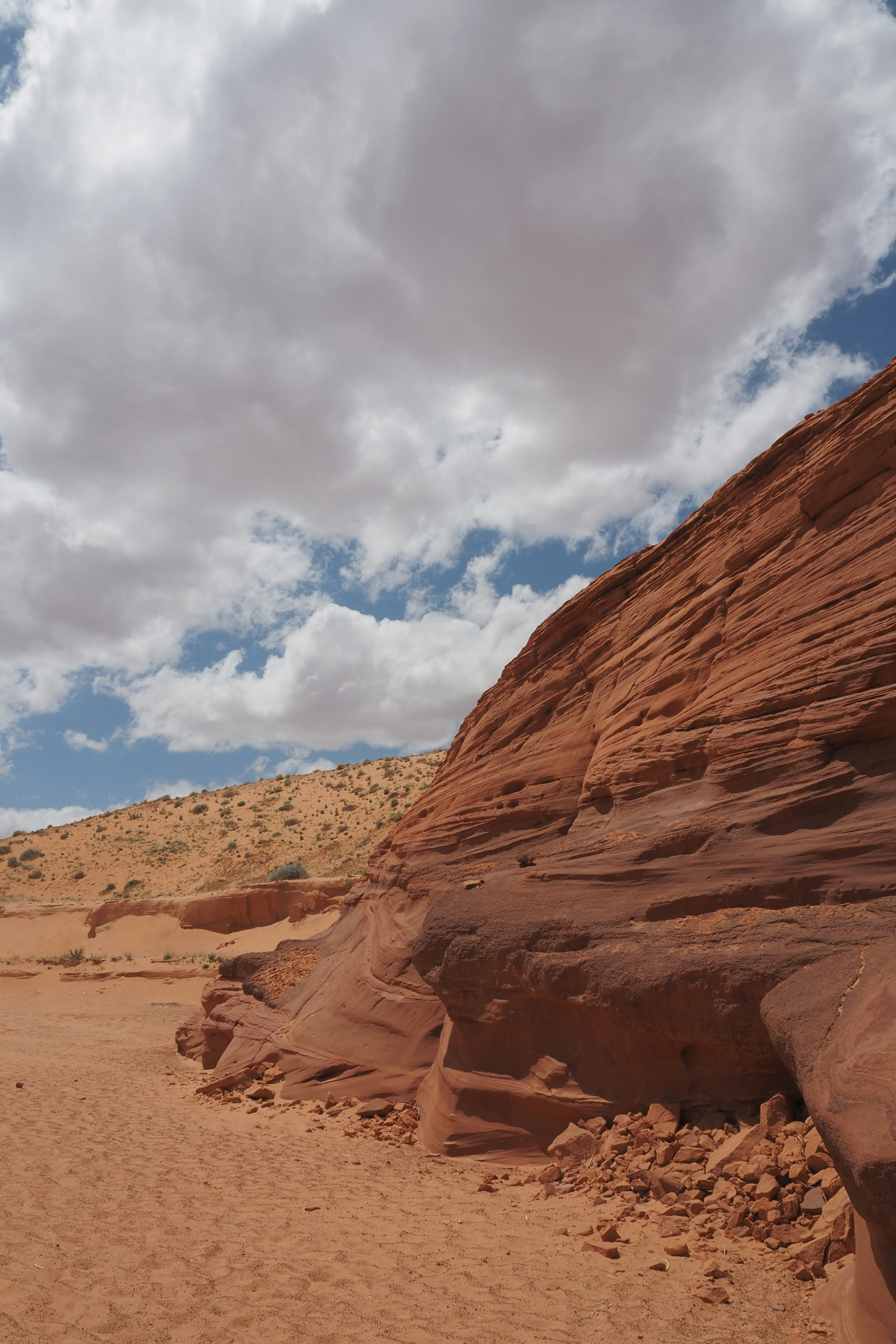 Paisaje desértico con formaciones rocosas rojas y dunas de arena