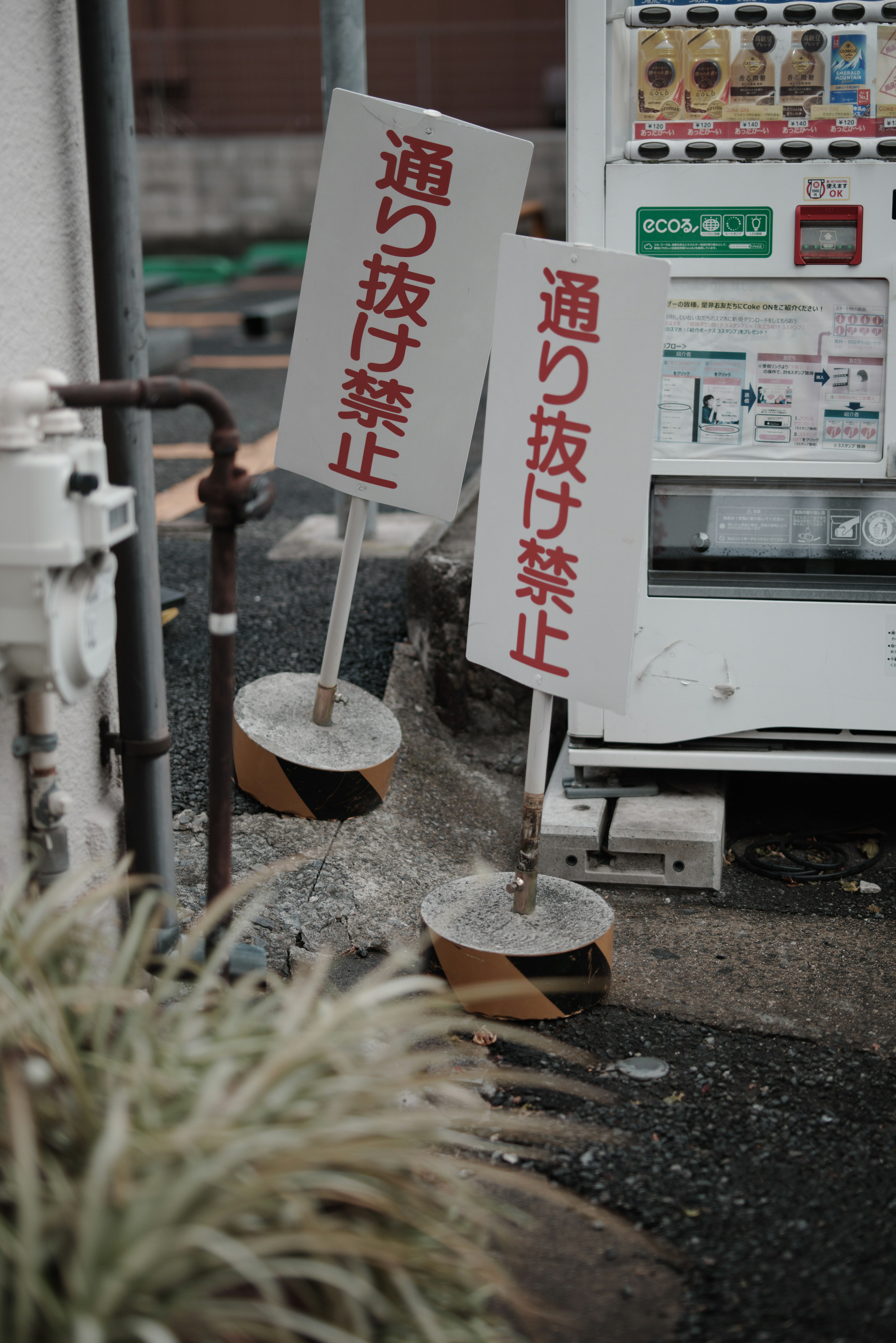 自動販売機の近くに立てられた二つの禁止看板