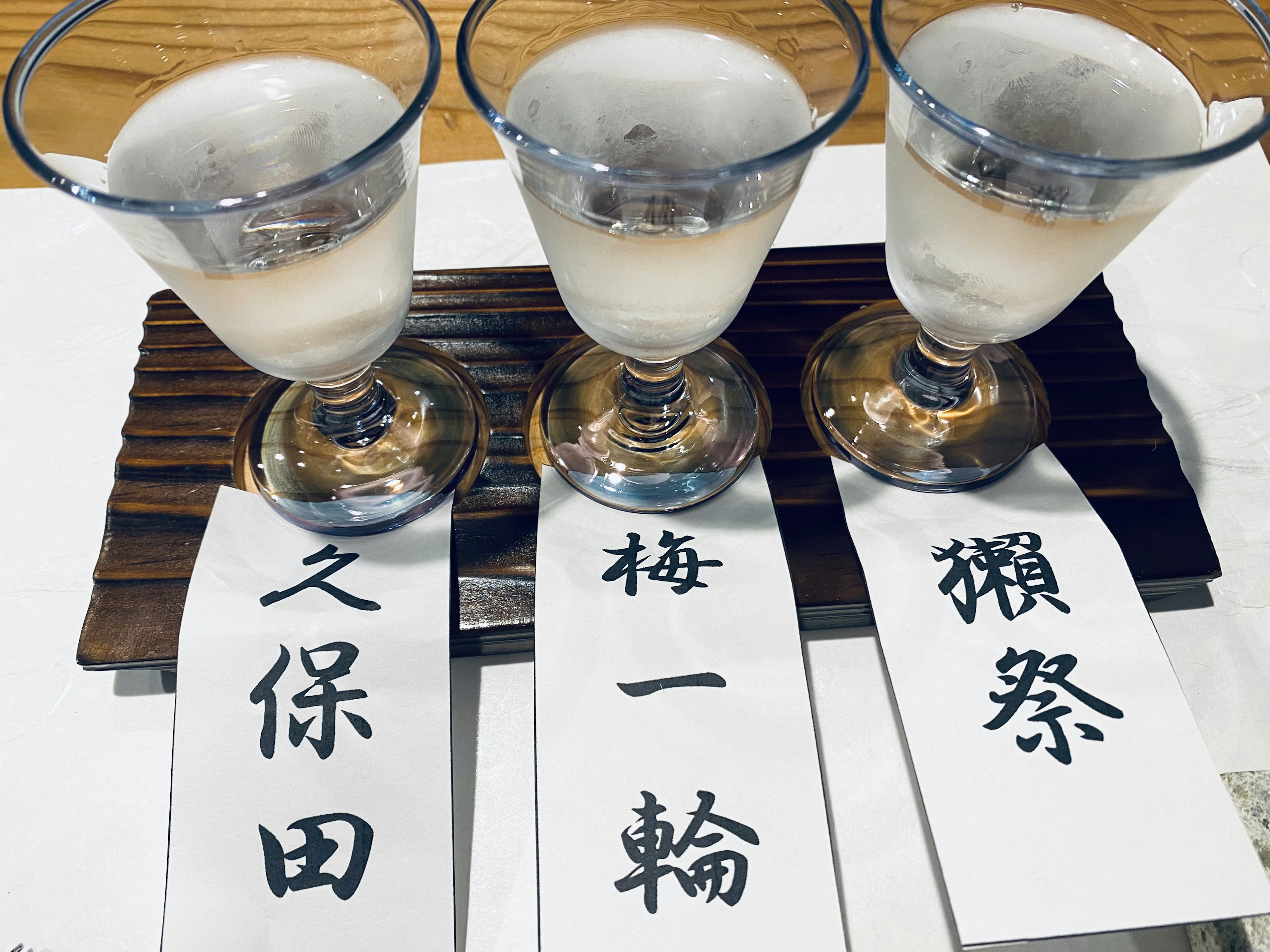 三个装有日本酒的杯子，上面有日文标签