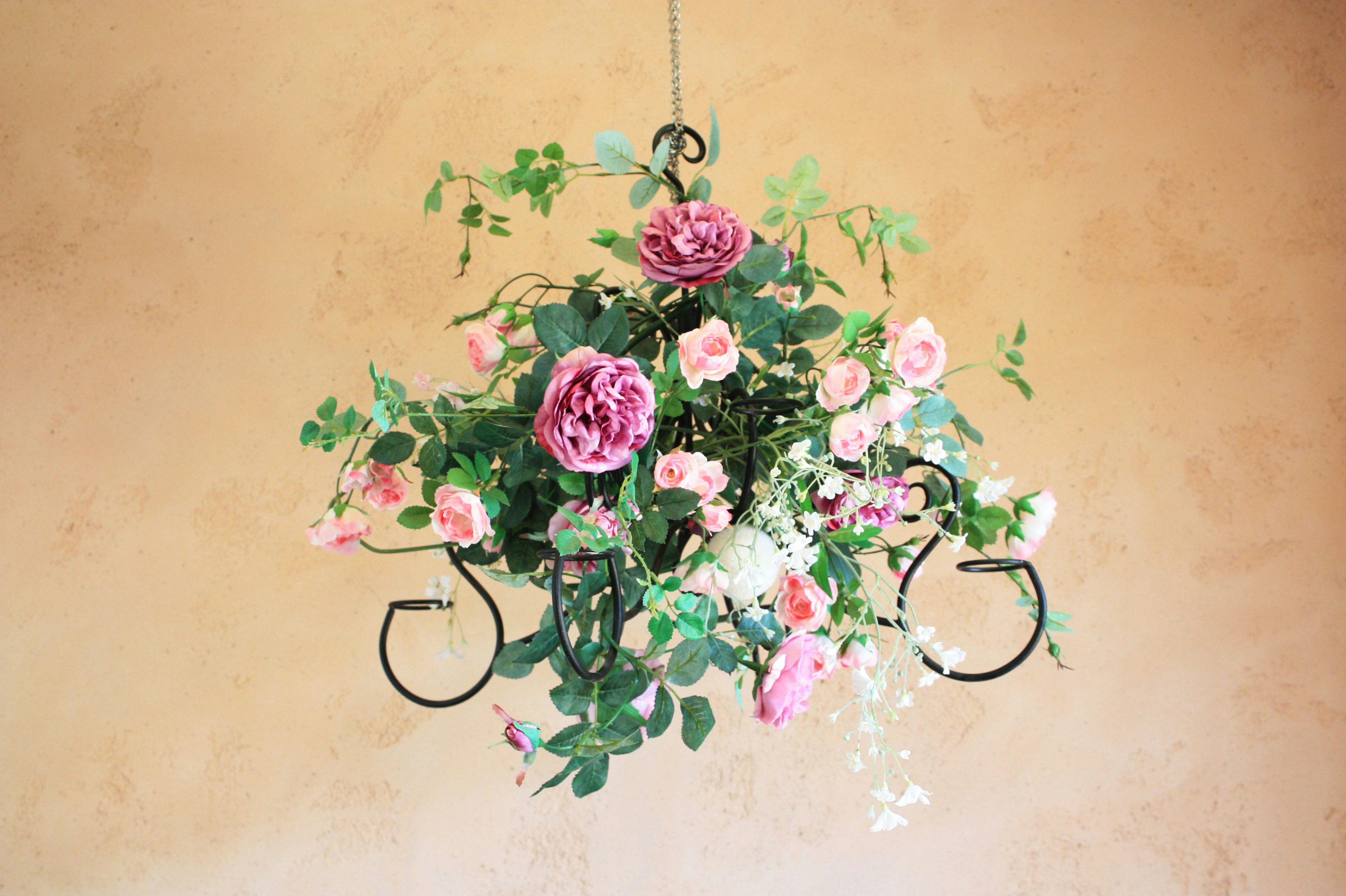 Hanging floral arrangement with pink flowers and green leaves