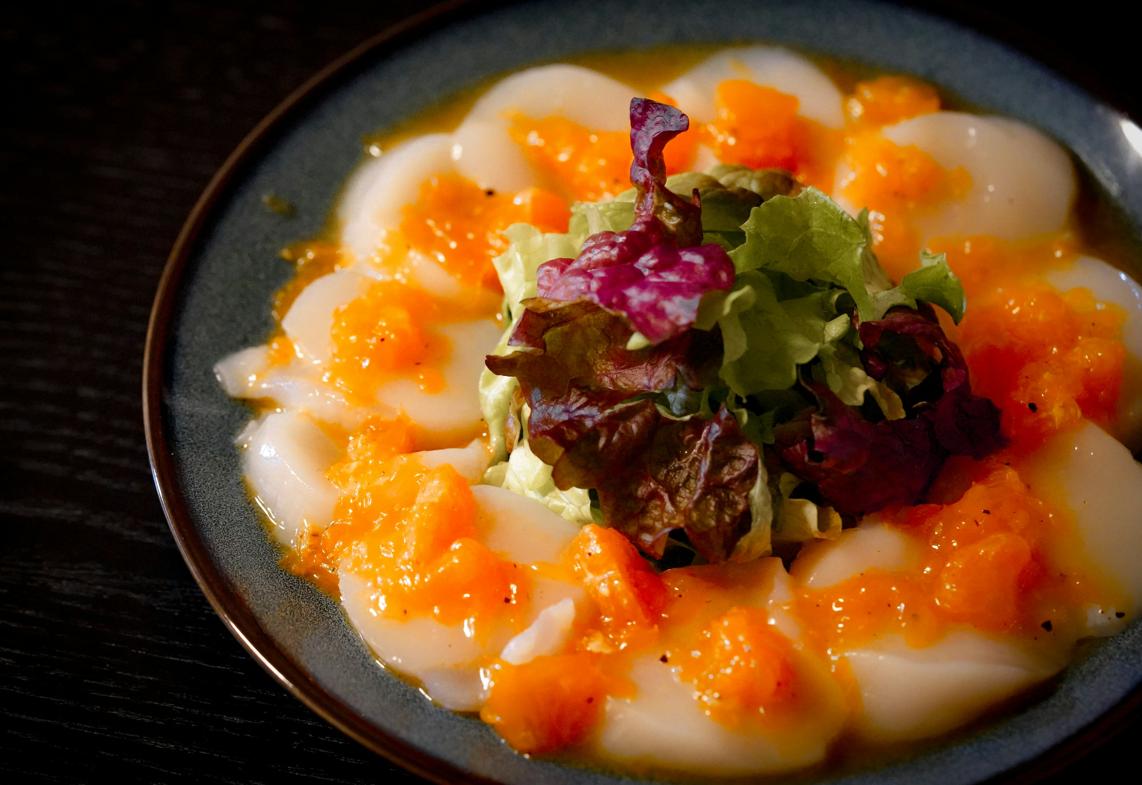 Salade de fruits de mer frais avec sauce orange servie sur une assiette