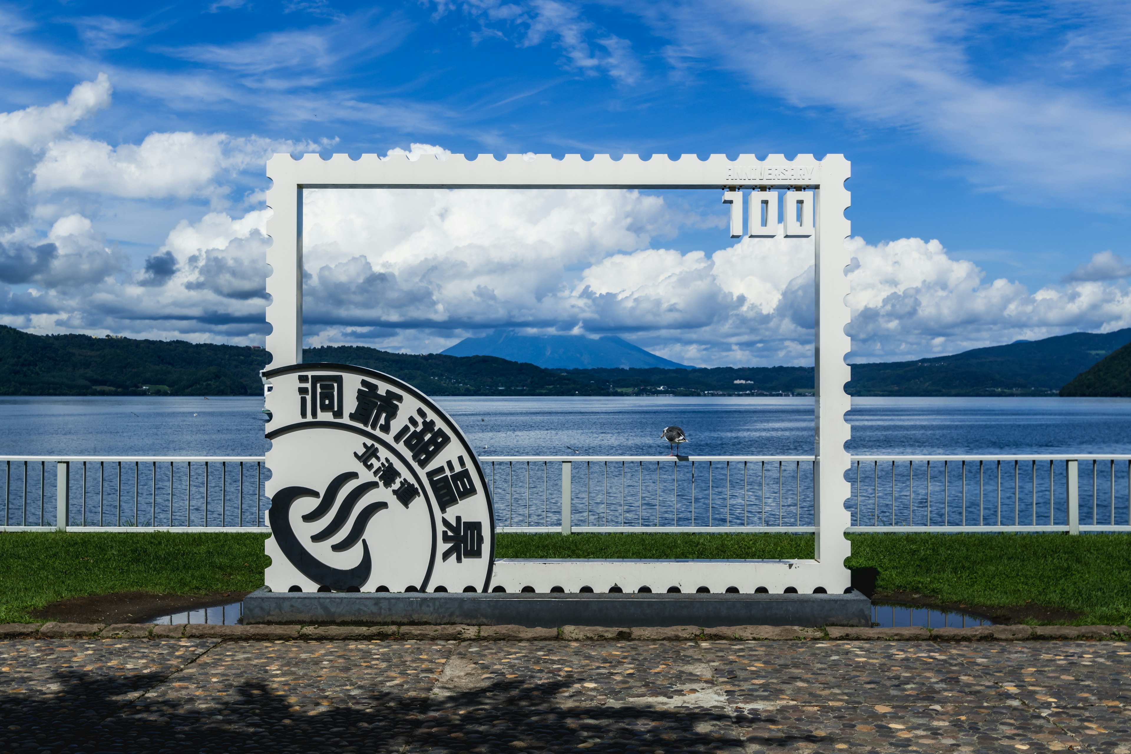 Large stamp-shaped frame with a lake and mountain background