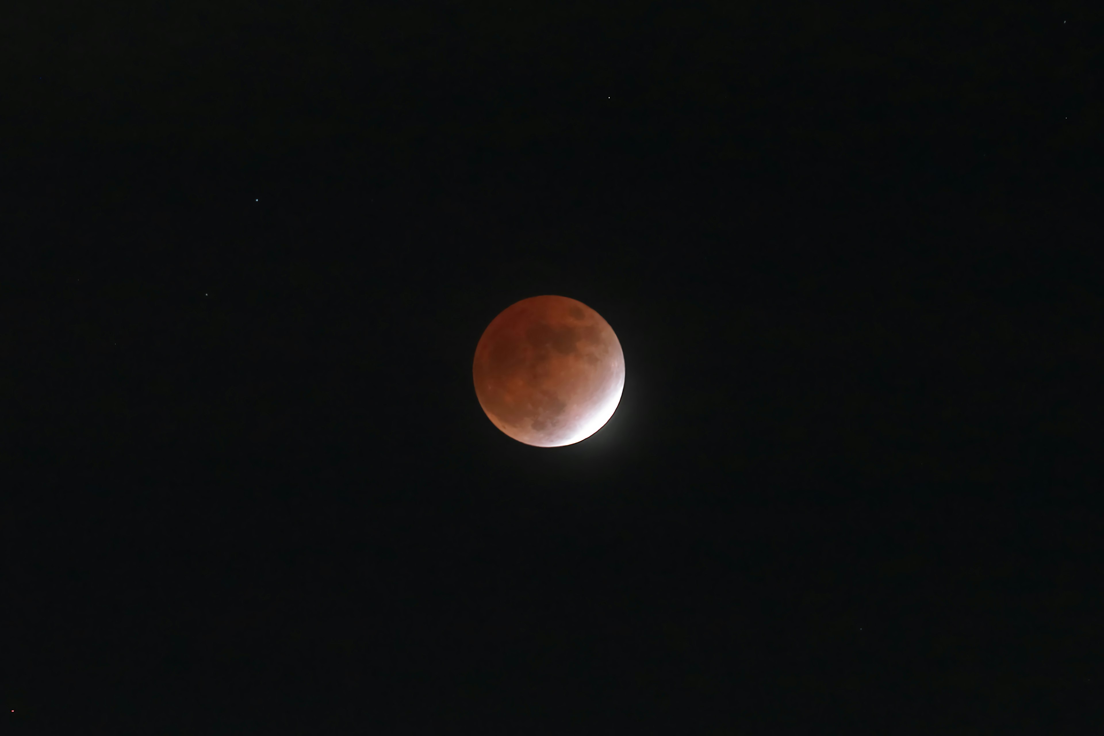 Immagine di una luna rossa durante un'eclissi lunare parziale