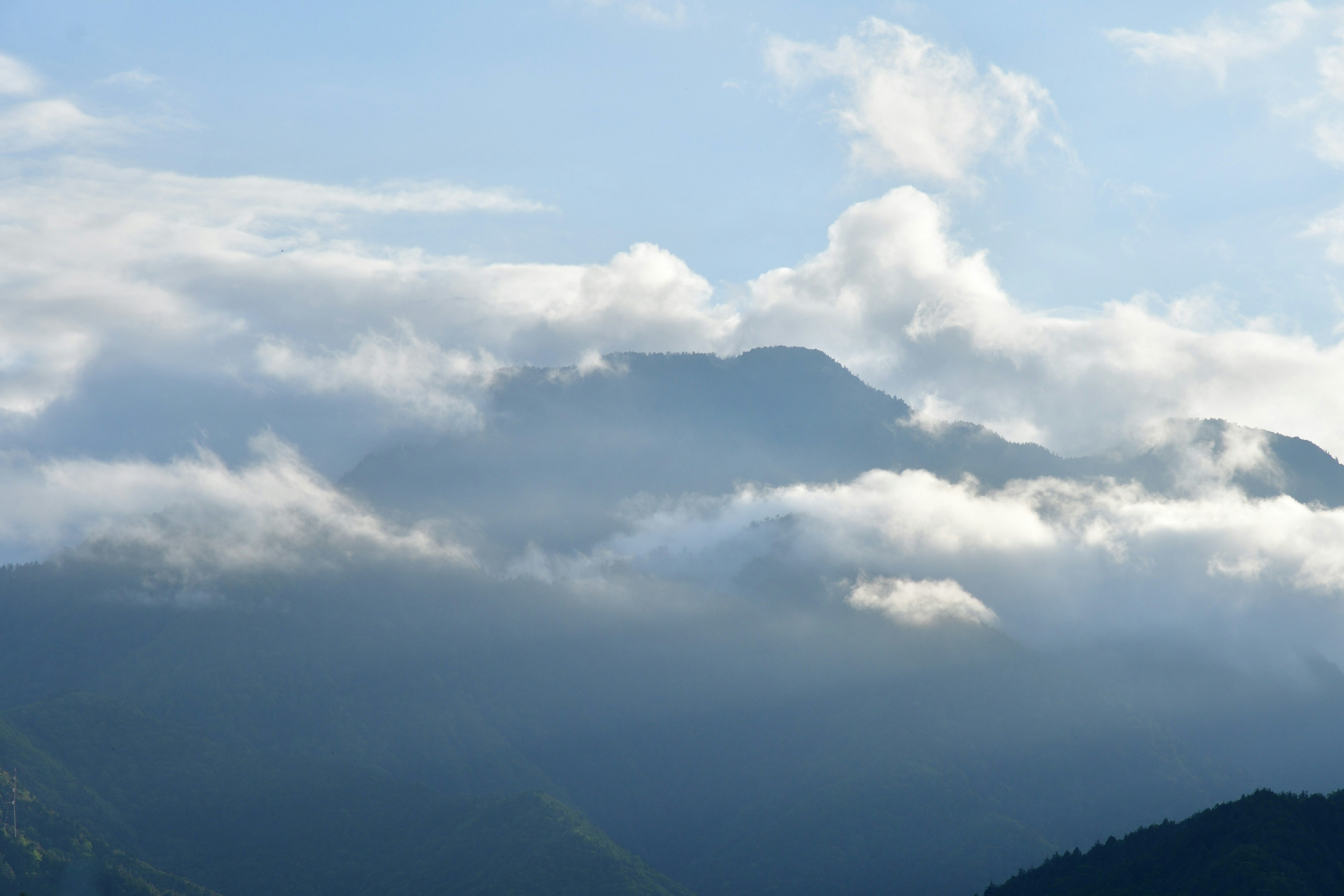 Mountain landscape shrouded in mist with blue sky