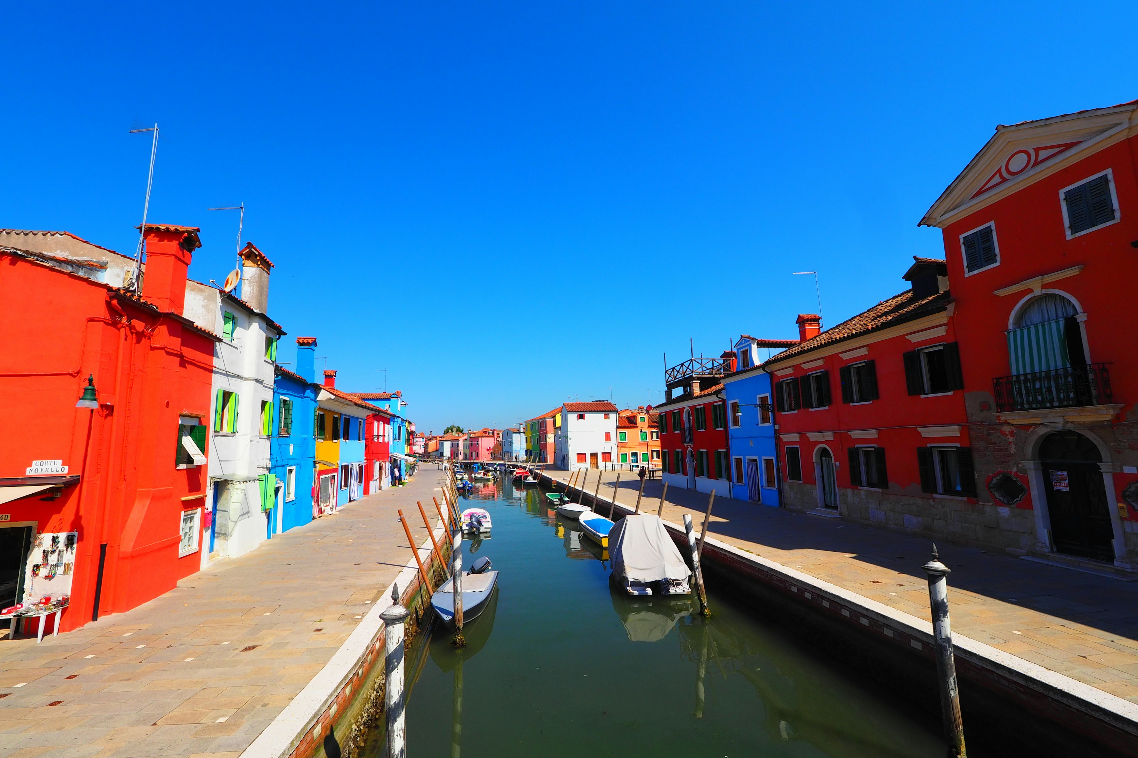 Colorful houses lining a canal under a clear blue sky