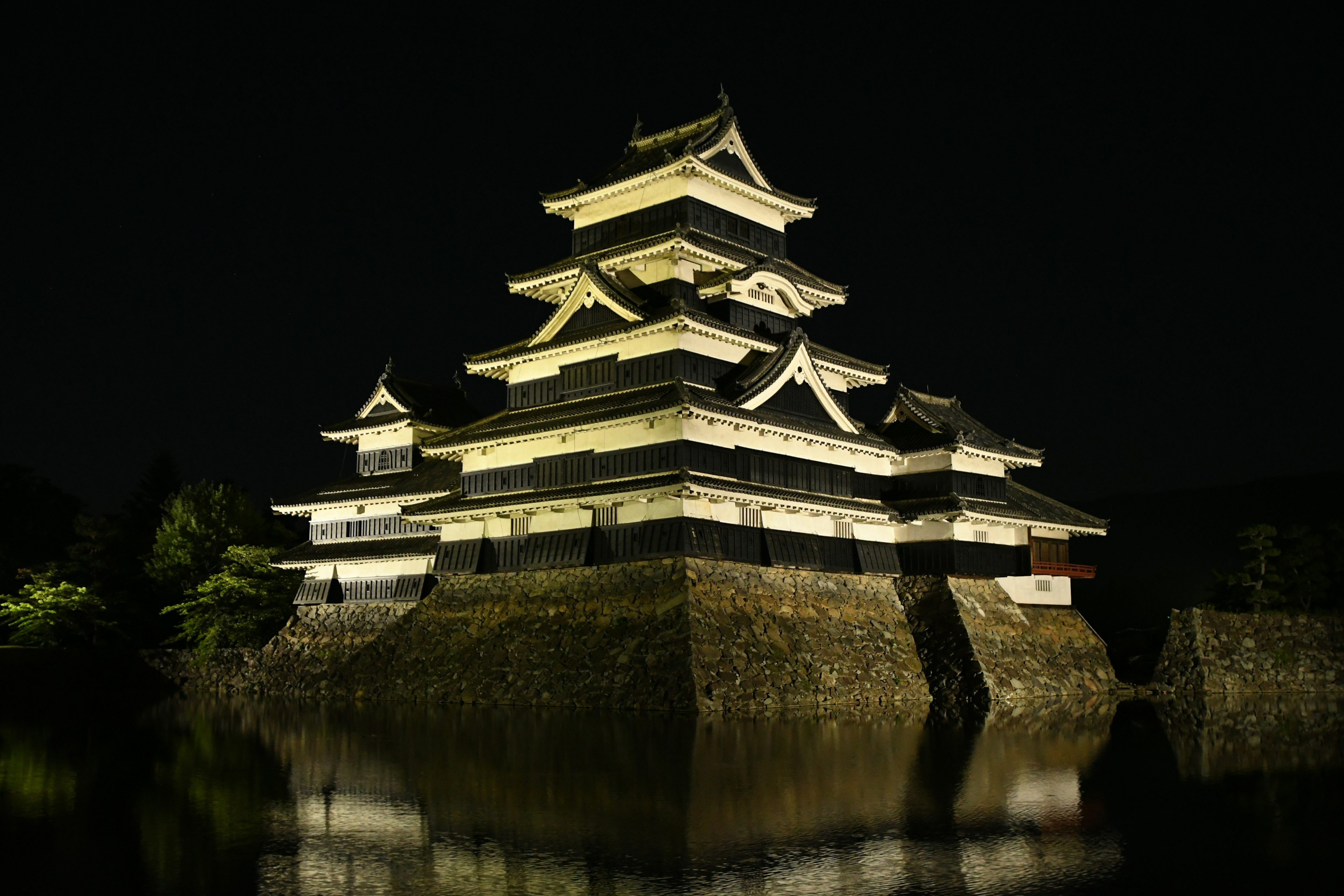 Château de Matsumoto illuminé la nuit avec réflexion