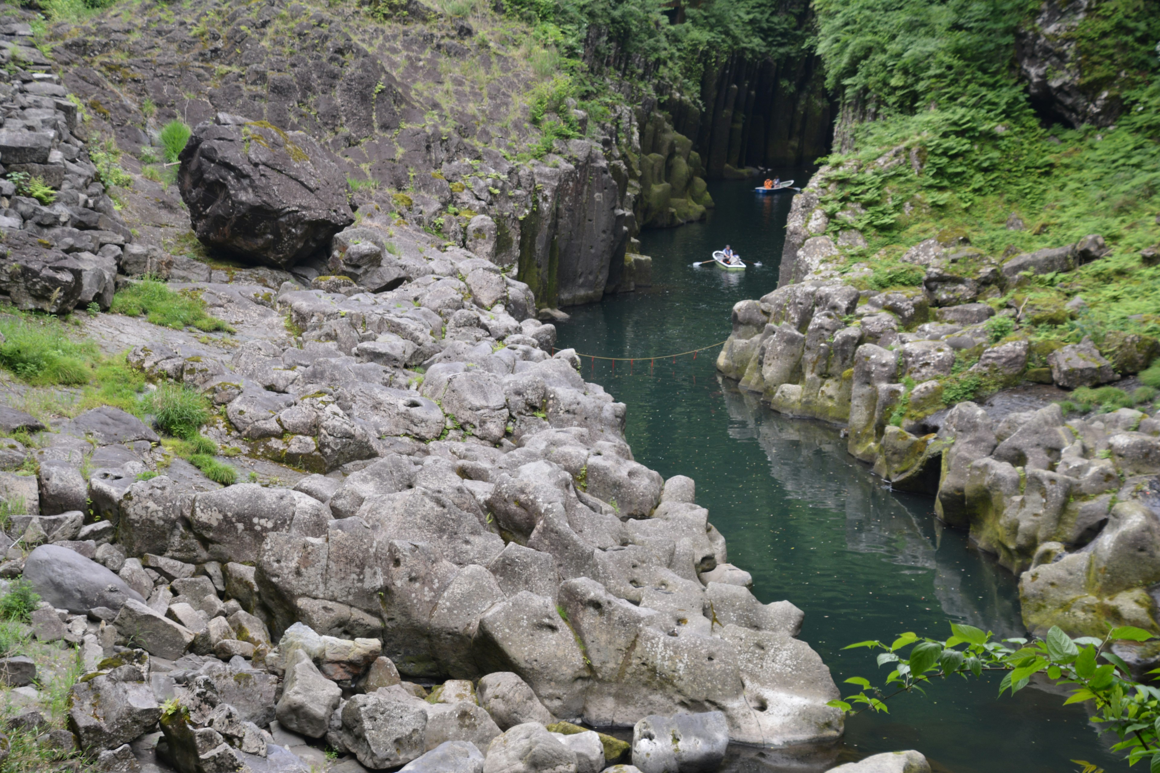 Vue panoramique d'une rivière tranquille entourée de rochers et de verdure luxuriante