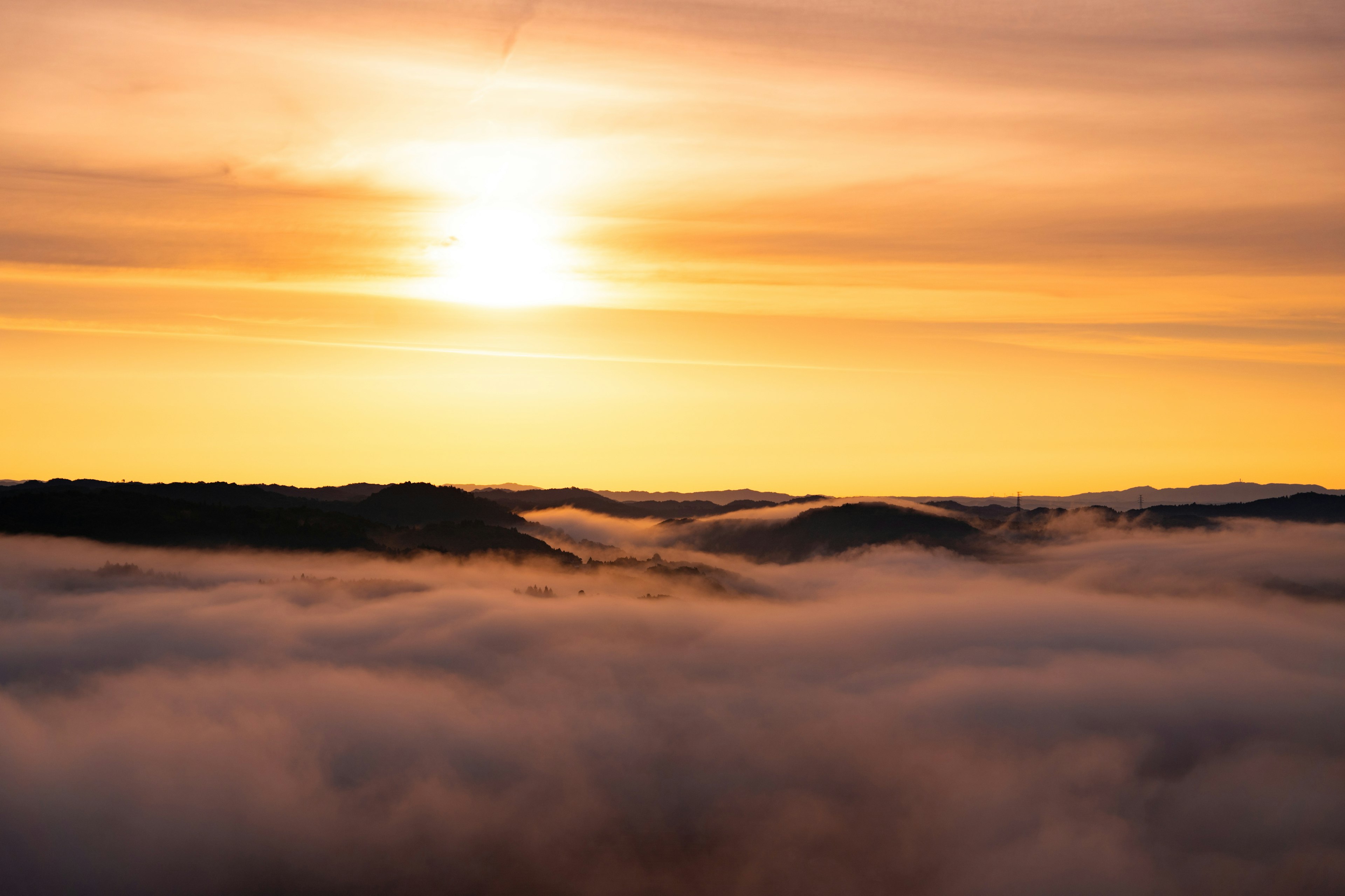 Paysage magnifique avec le coucher de soleil illuminant la mer de nuages