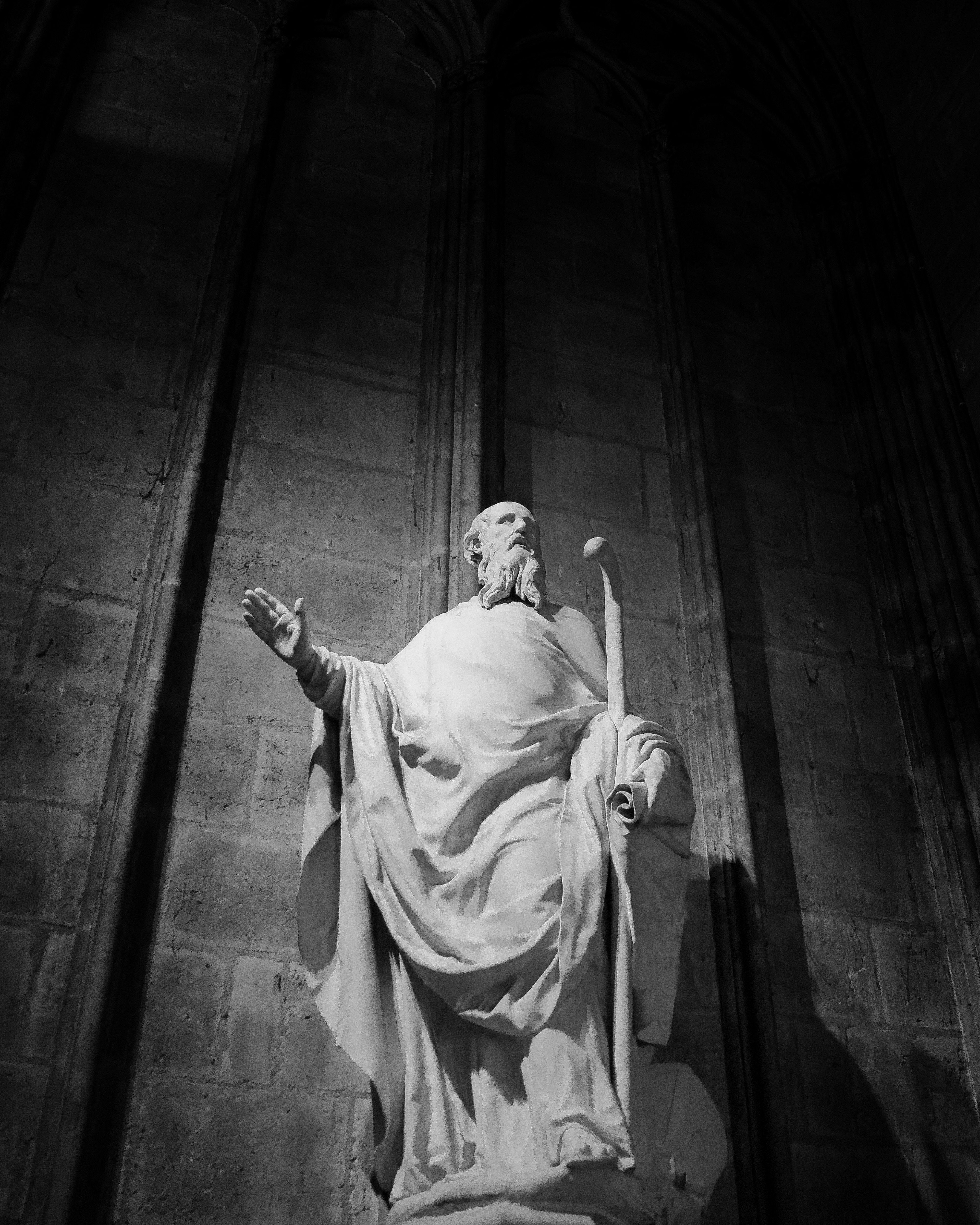 A striking white sculpture of a figure in a church interior