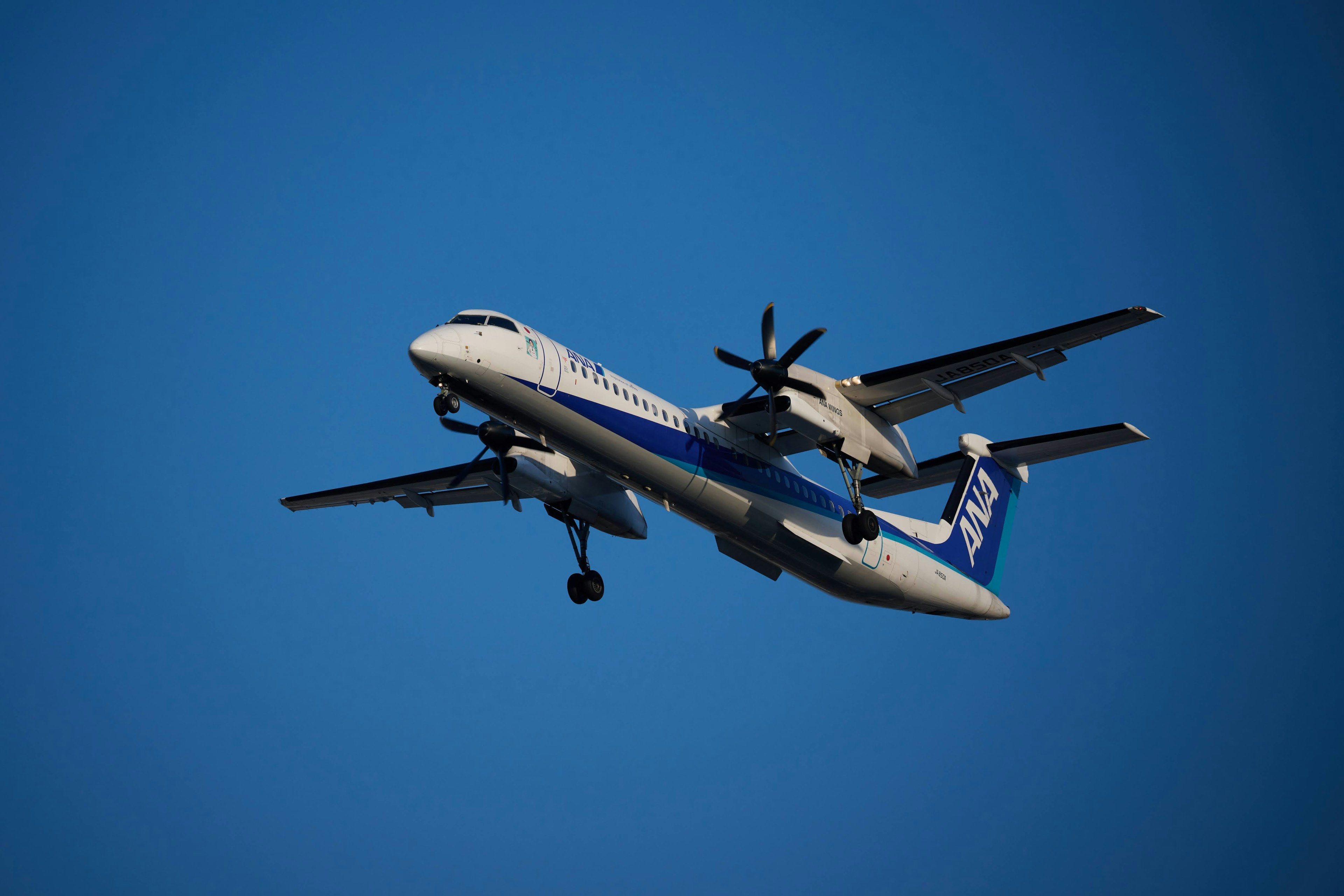 Propeller airplane flying against a blue sky