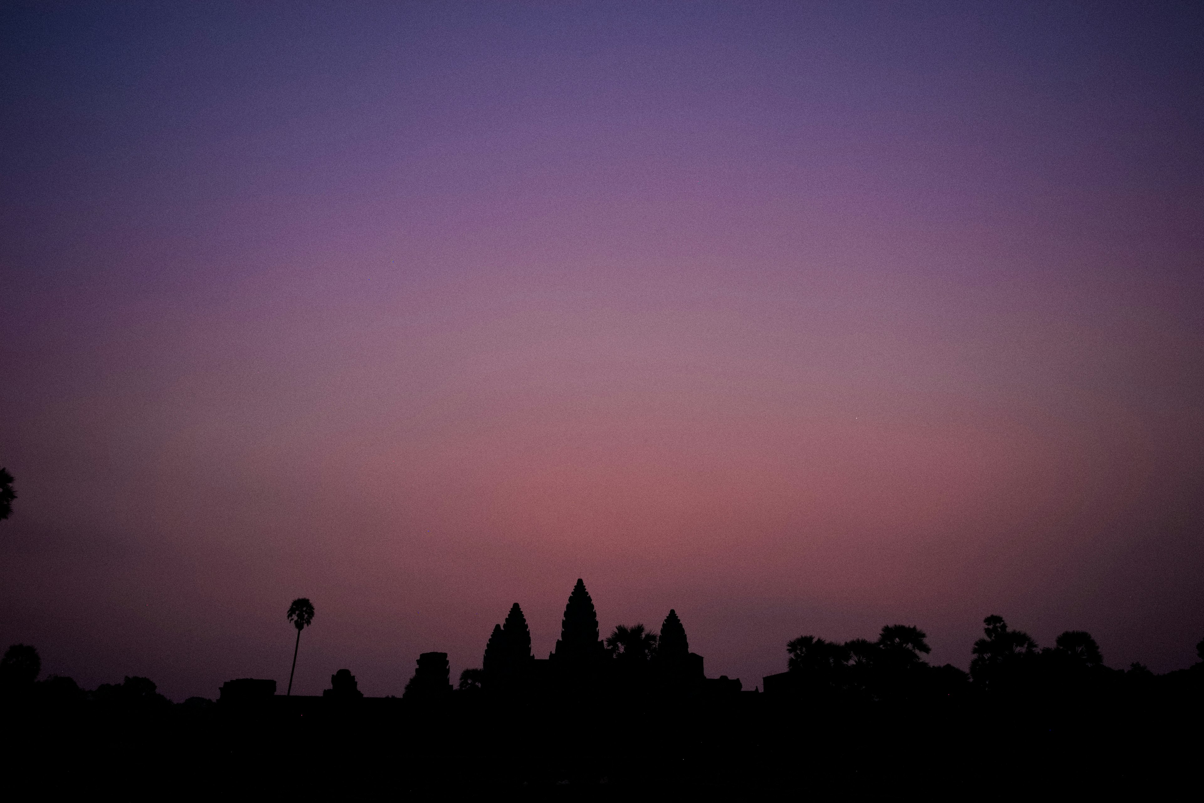 Cielo al atardecer con siluetas de estructuras de templo