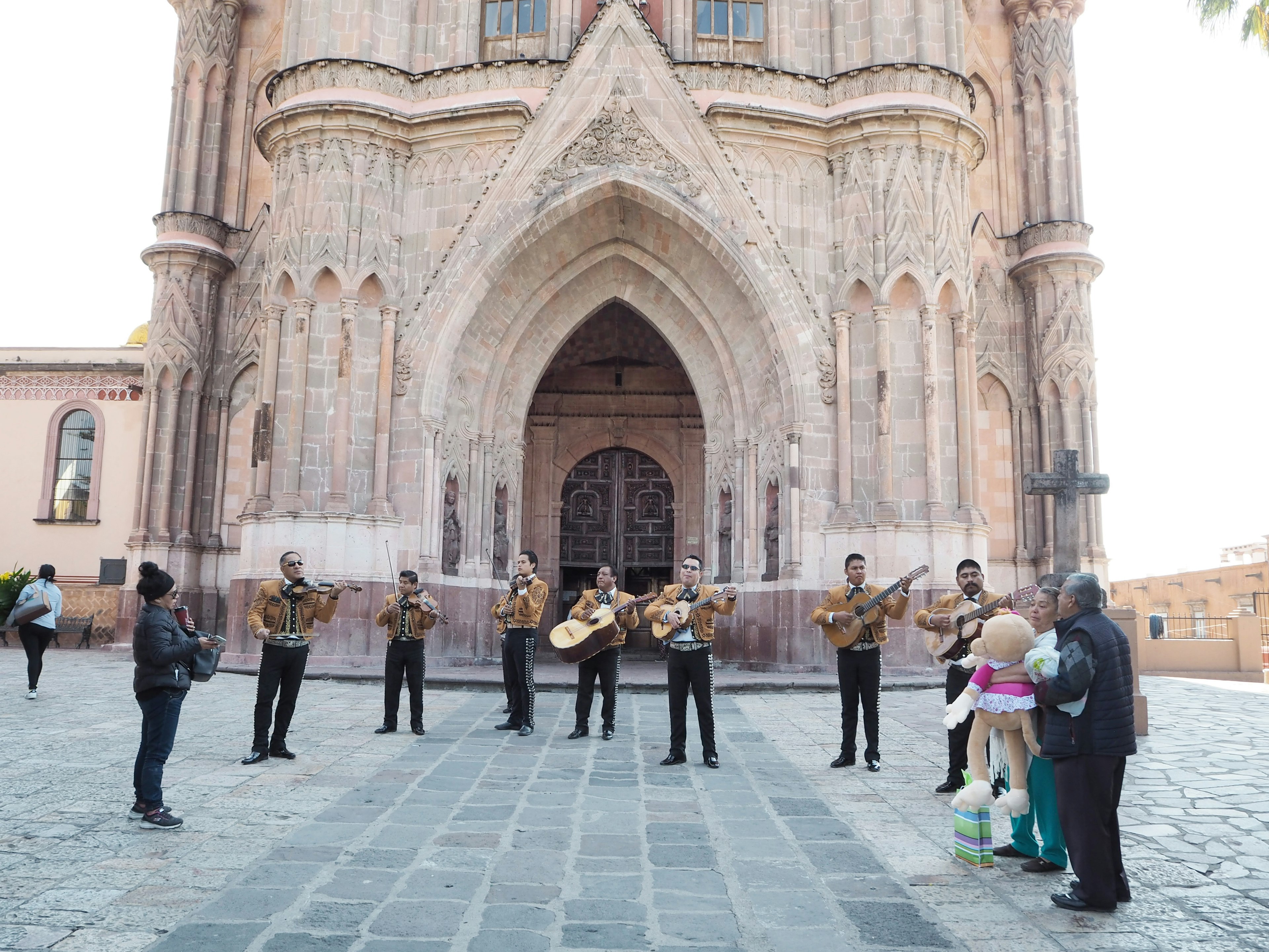 Gruppo di mariachi che si esibisce davanti a una bella chiesa con pubblico