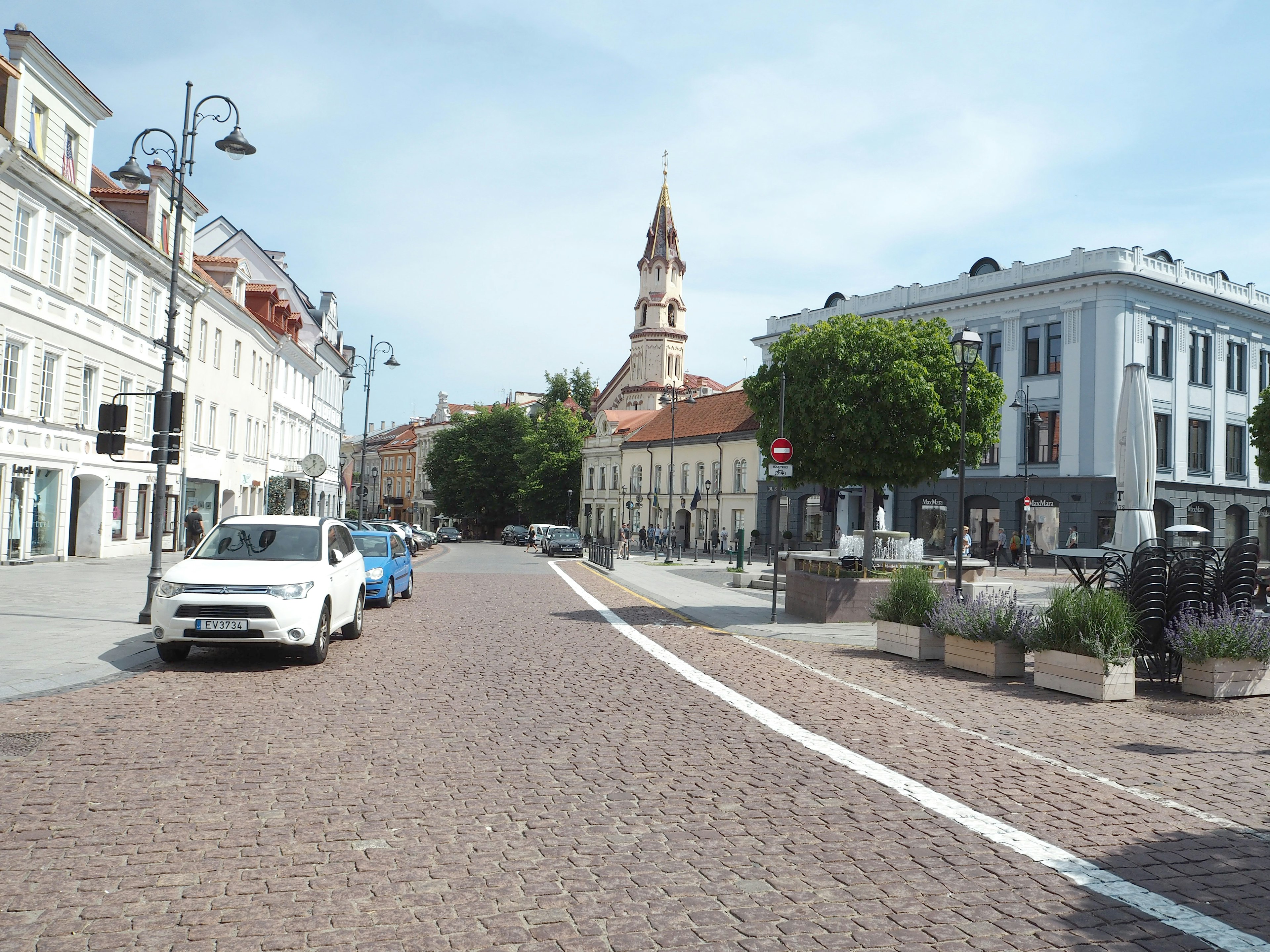 Quiet street with cobblestones featuring a historic church tower in the background