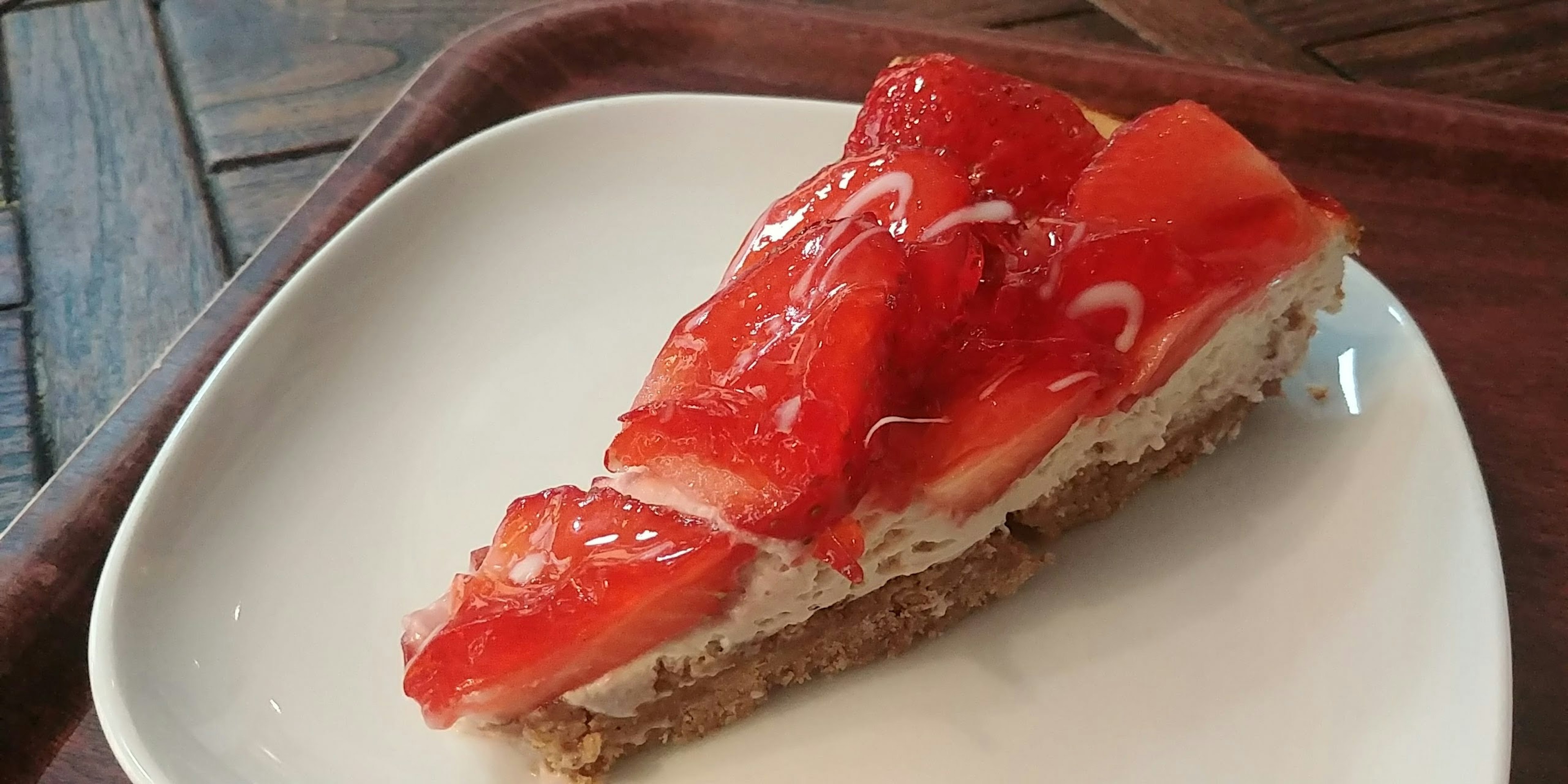 Slice of strawberry tart on a white plate