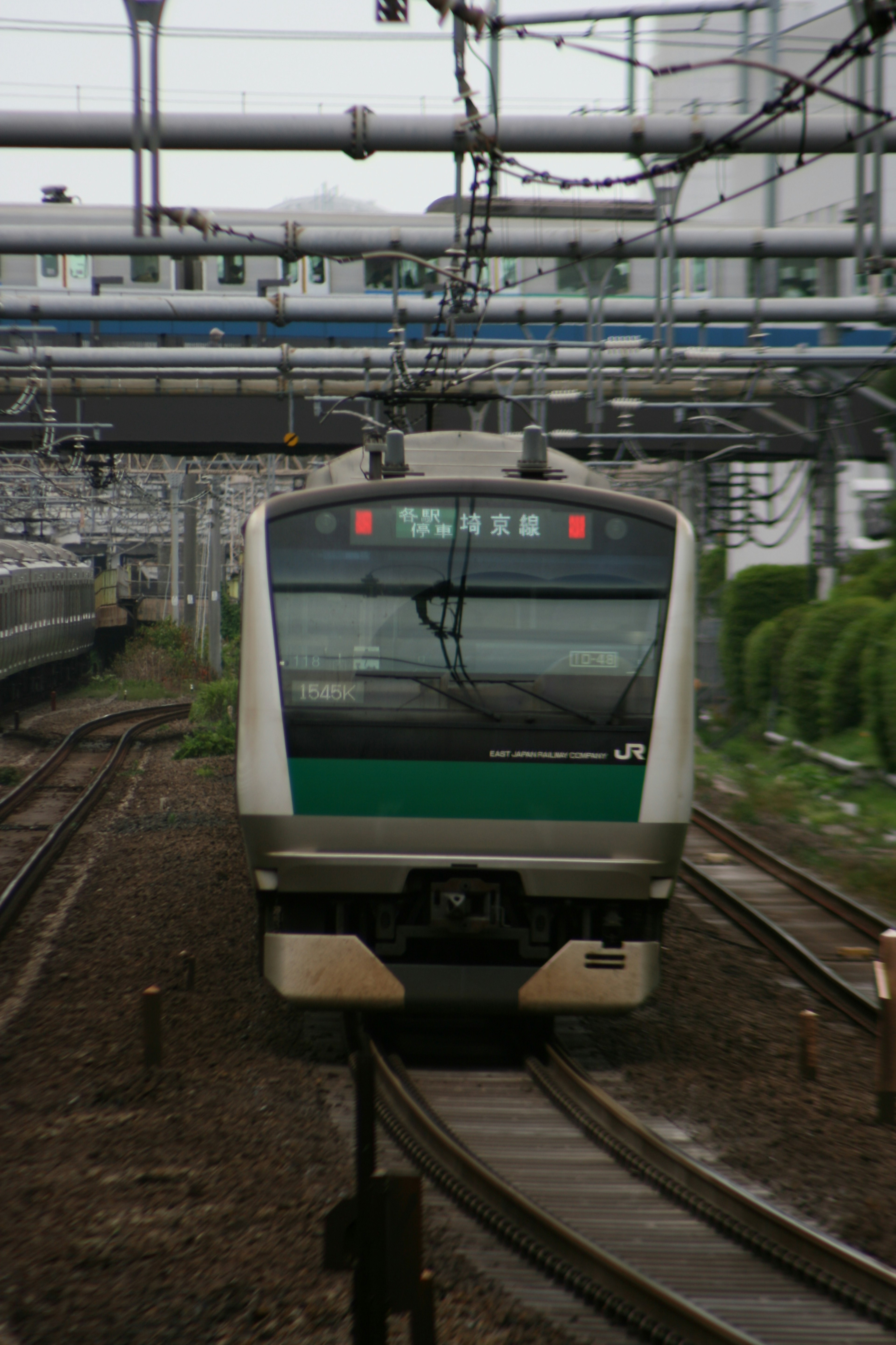 Green JR train approaching on the tracks