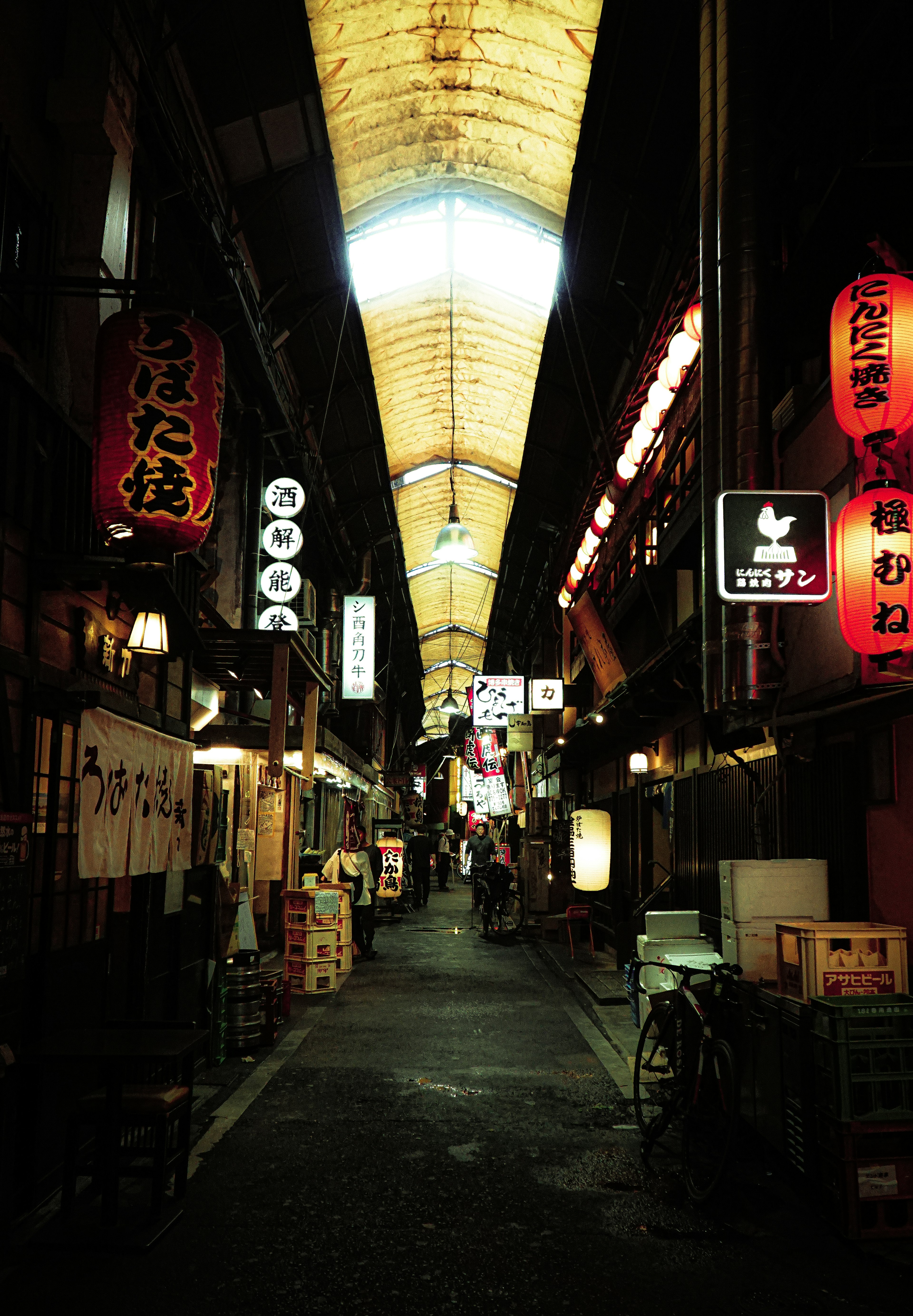 Narrow alley filled with restaurants and neon signs