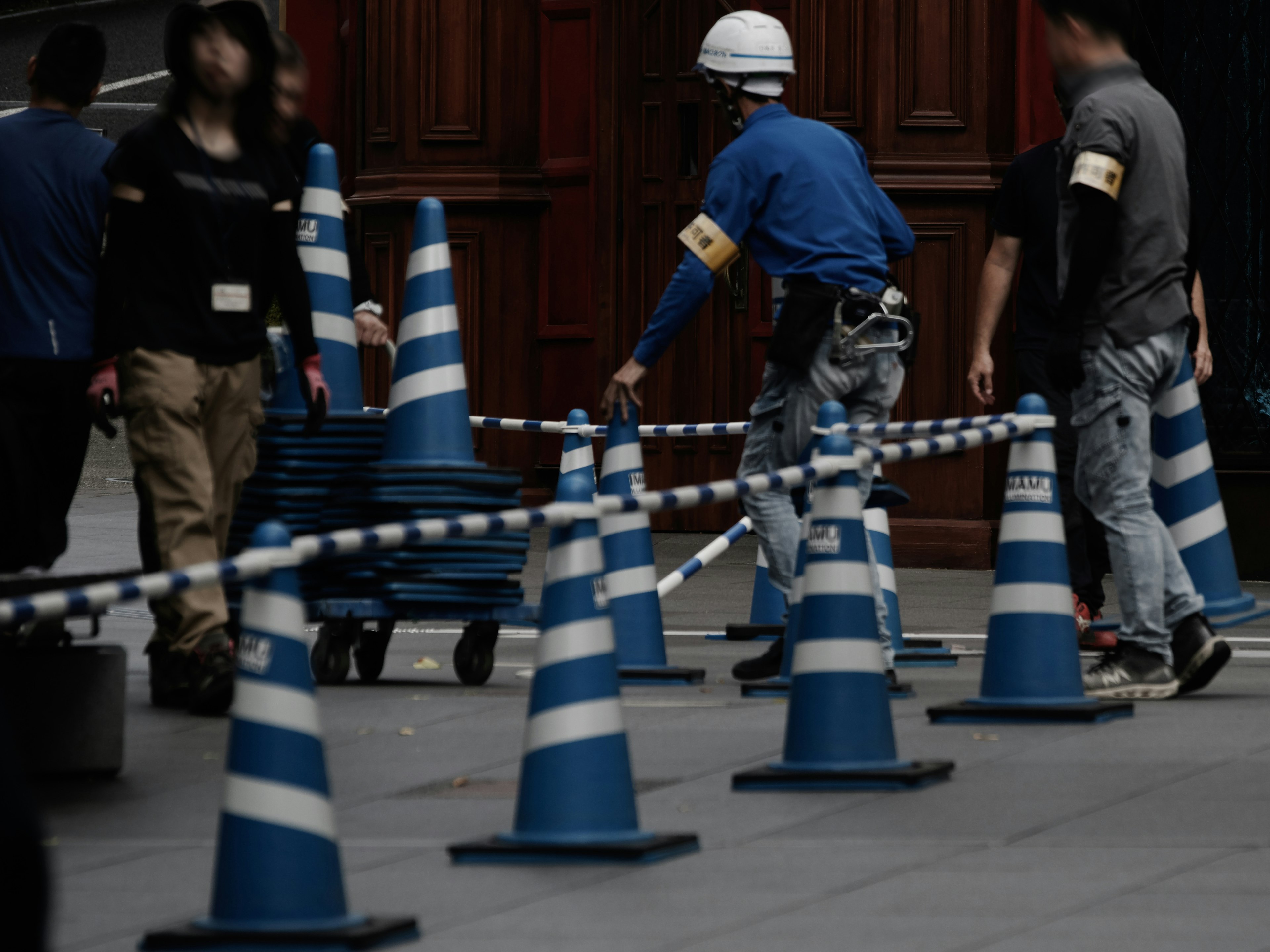 Workers at a construction site with blue and white traffic cones