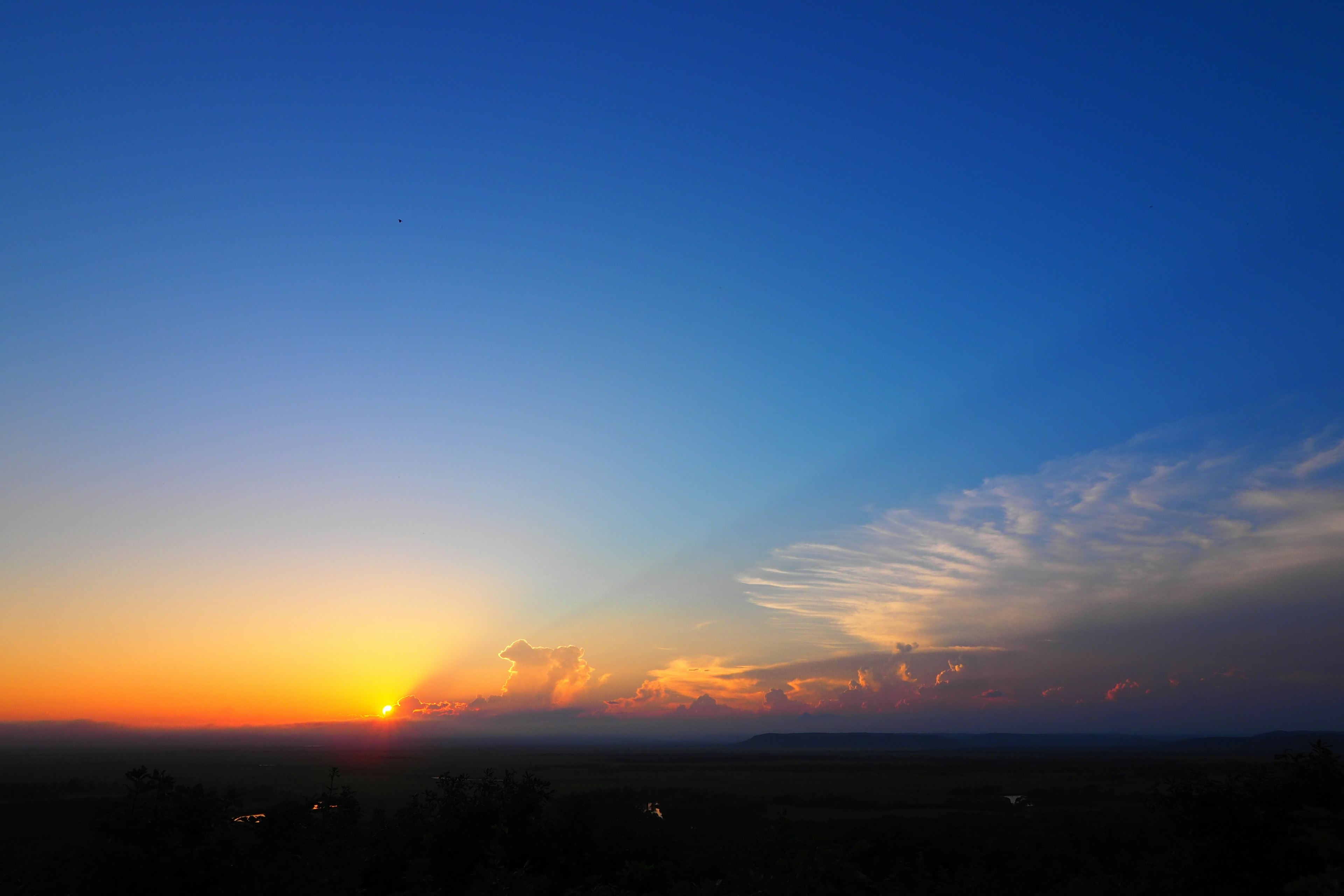 Stunning sunset over a horizon with a gradient from blue to orange