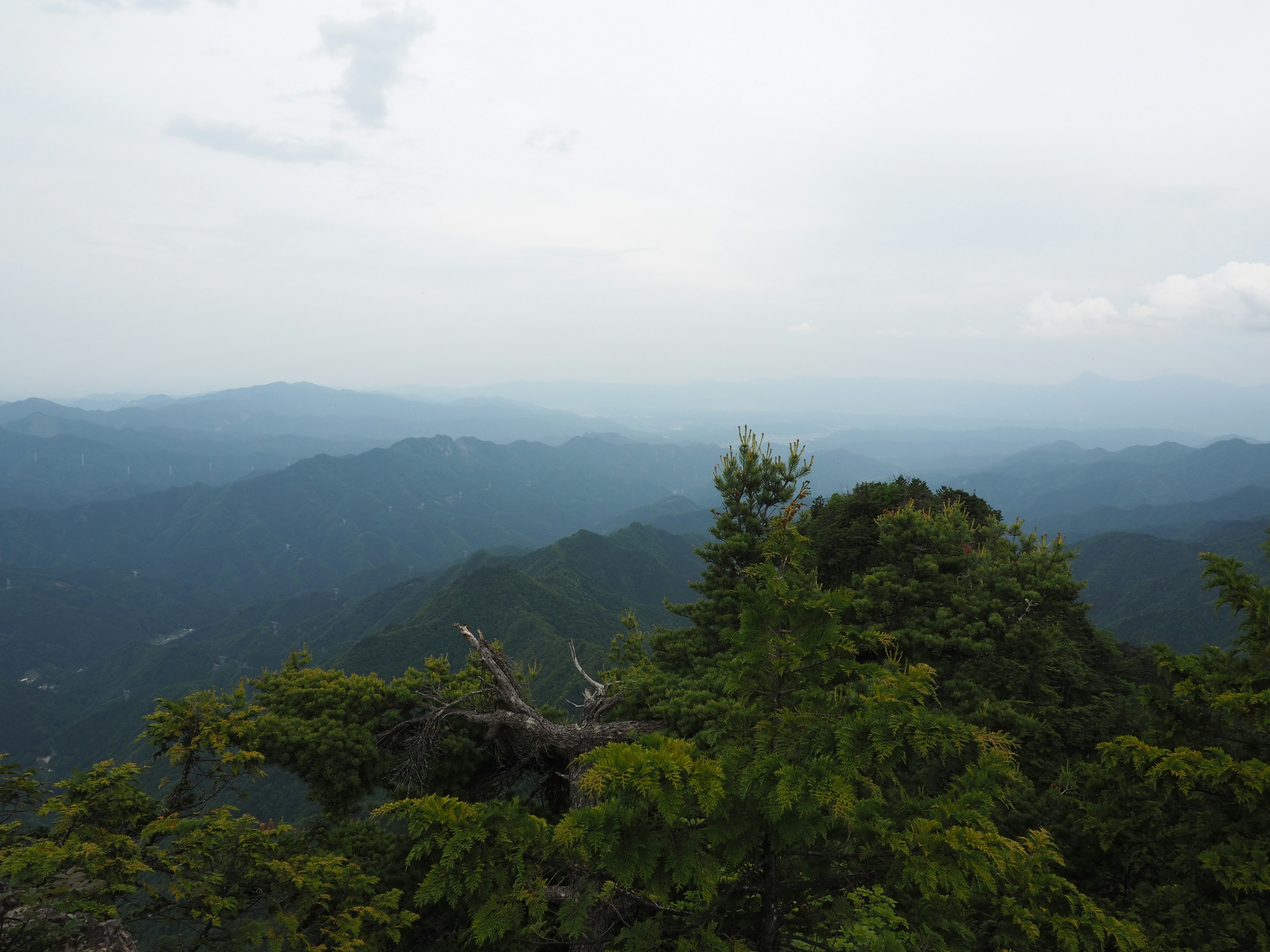 Vista panoramica di montagne blu e nuvole con cielo leggermente nebbioso