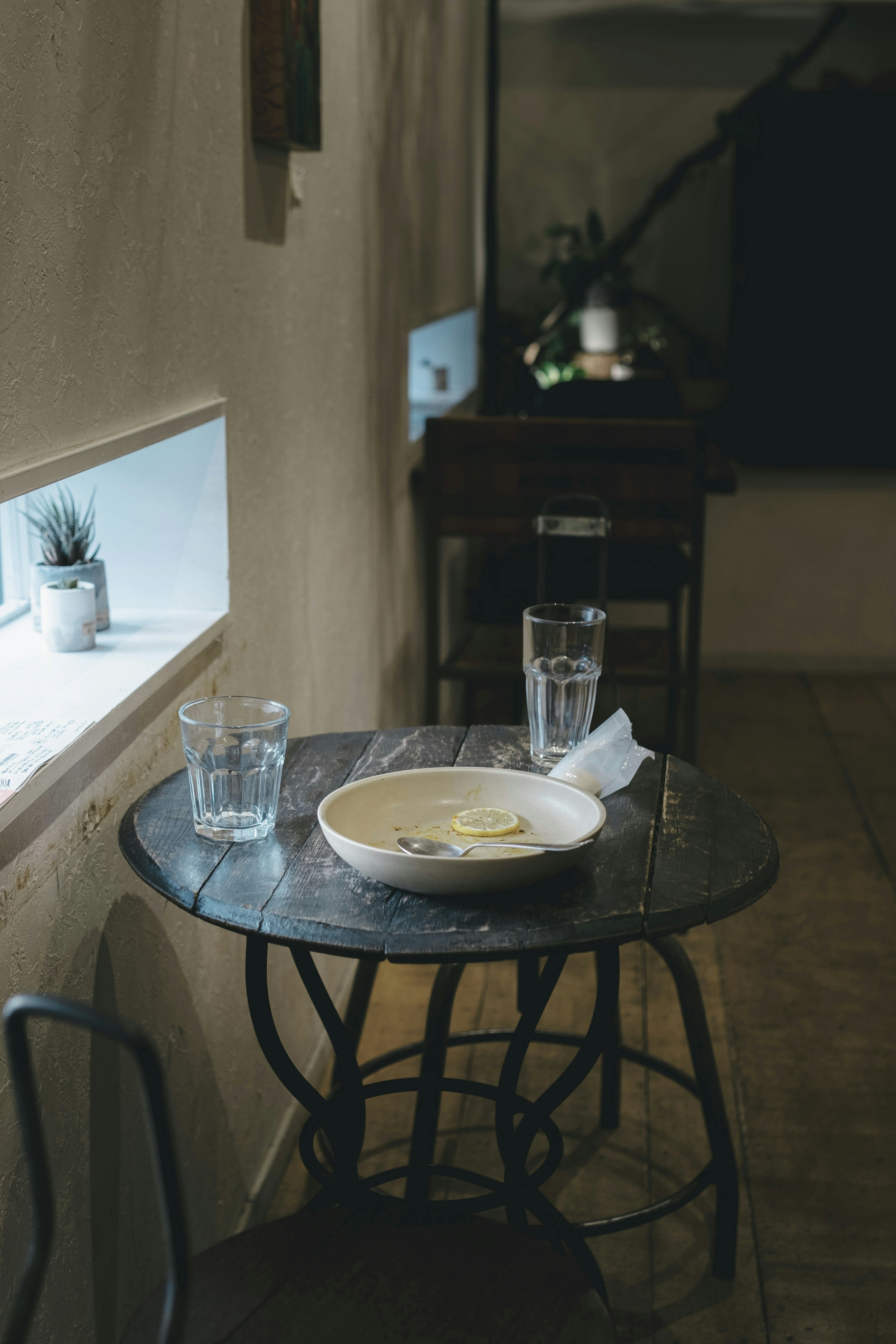 Una escena de café simple con un plato y vasos de agua en una mesa