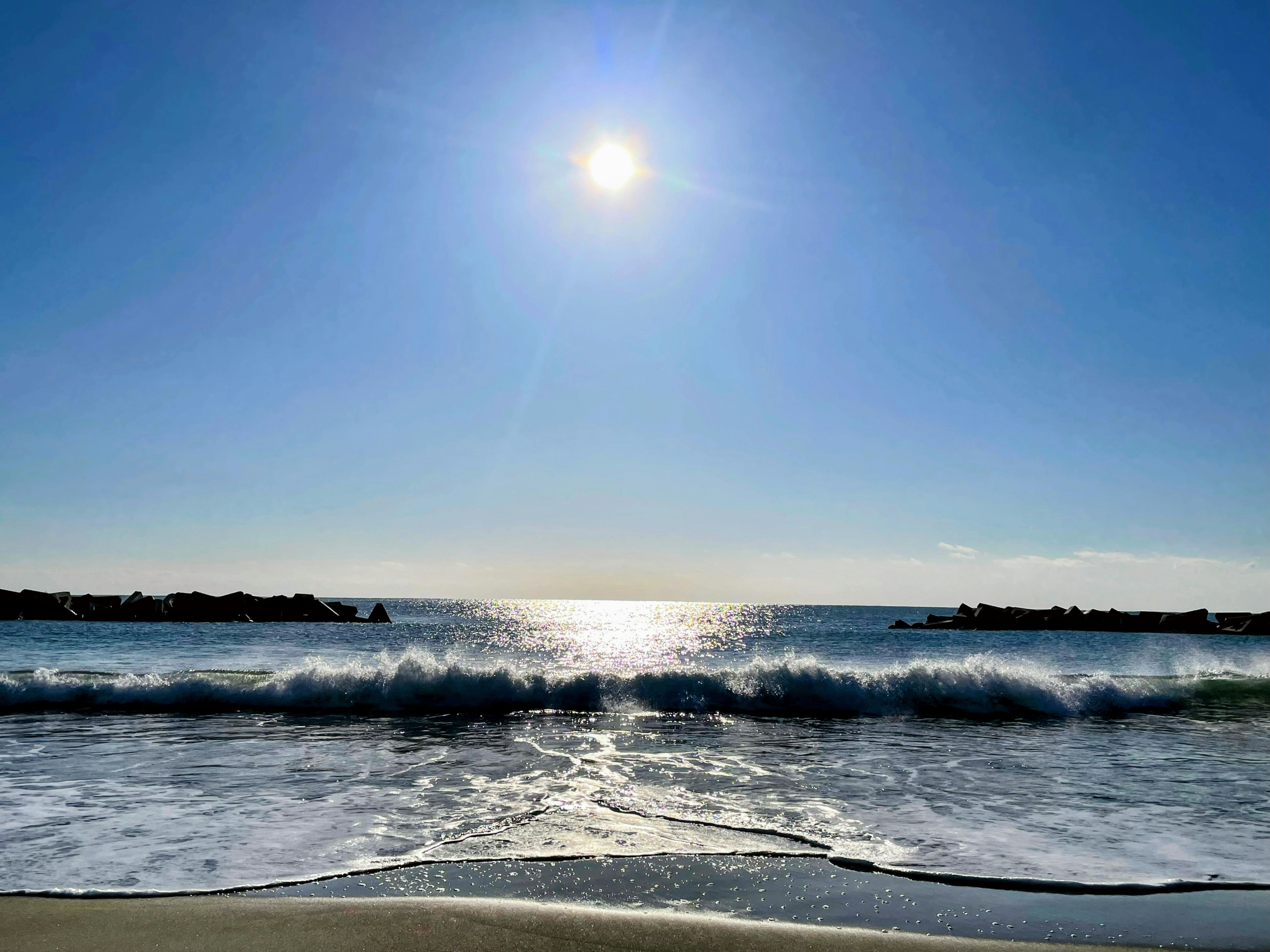 青空と太陽の下の海岸の風景波が打ち寄せるシーン