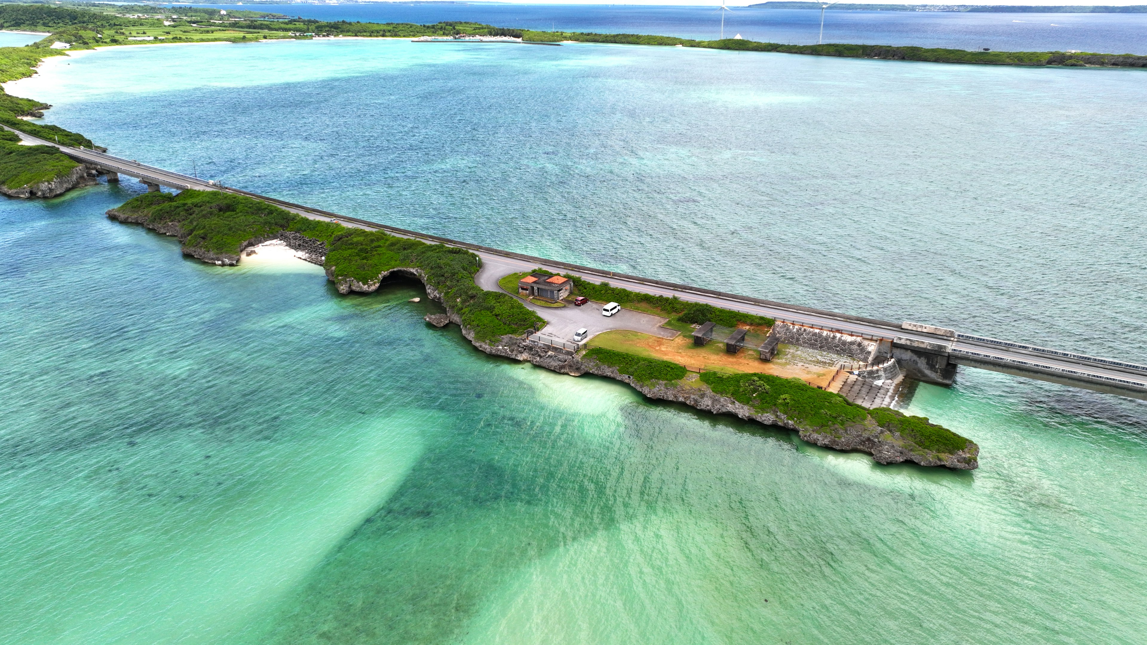 青い海と緑の岸が広がる風景 橋が海を横断し 近くに公園がある