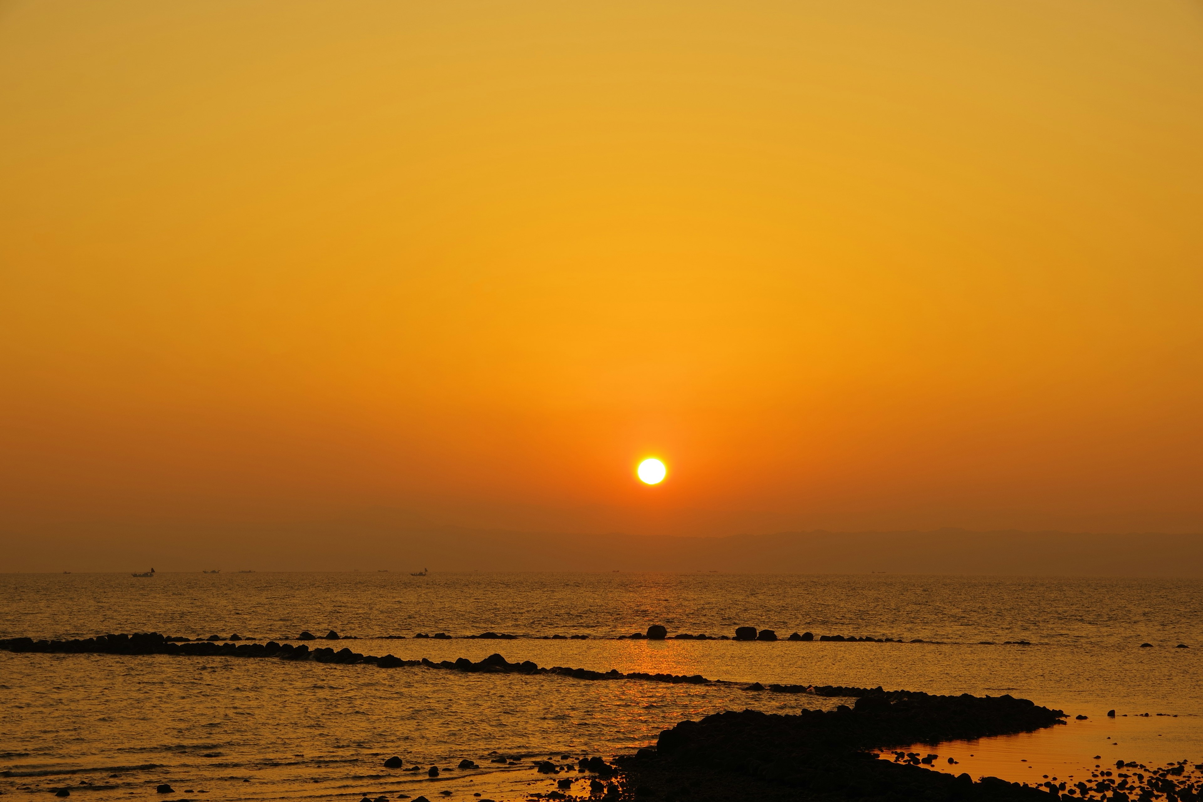 Magnifique coucher de soleil sur l'océan avec un ciel orange et des eaux calmes