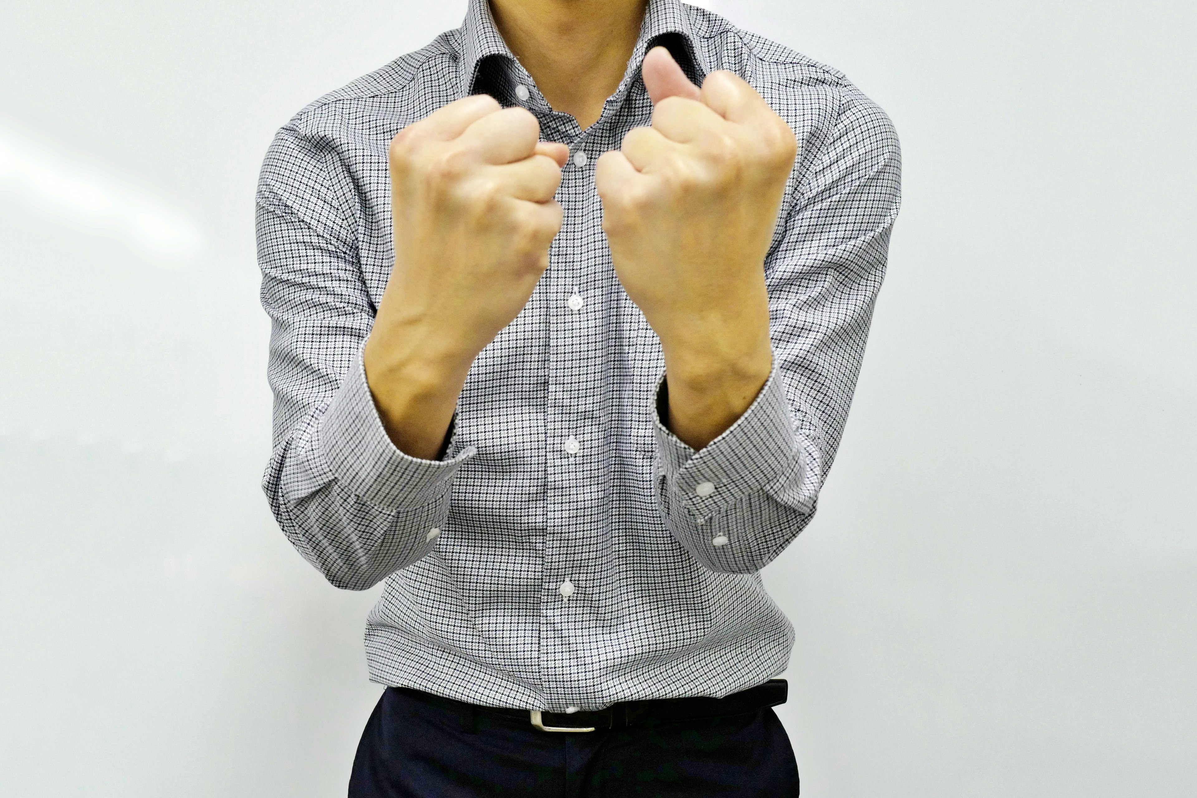 A man with clenched fists in front of a white background