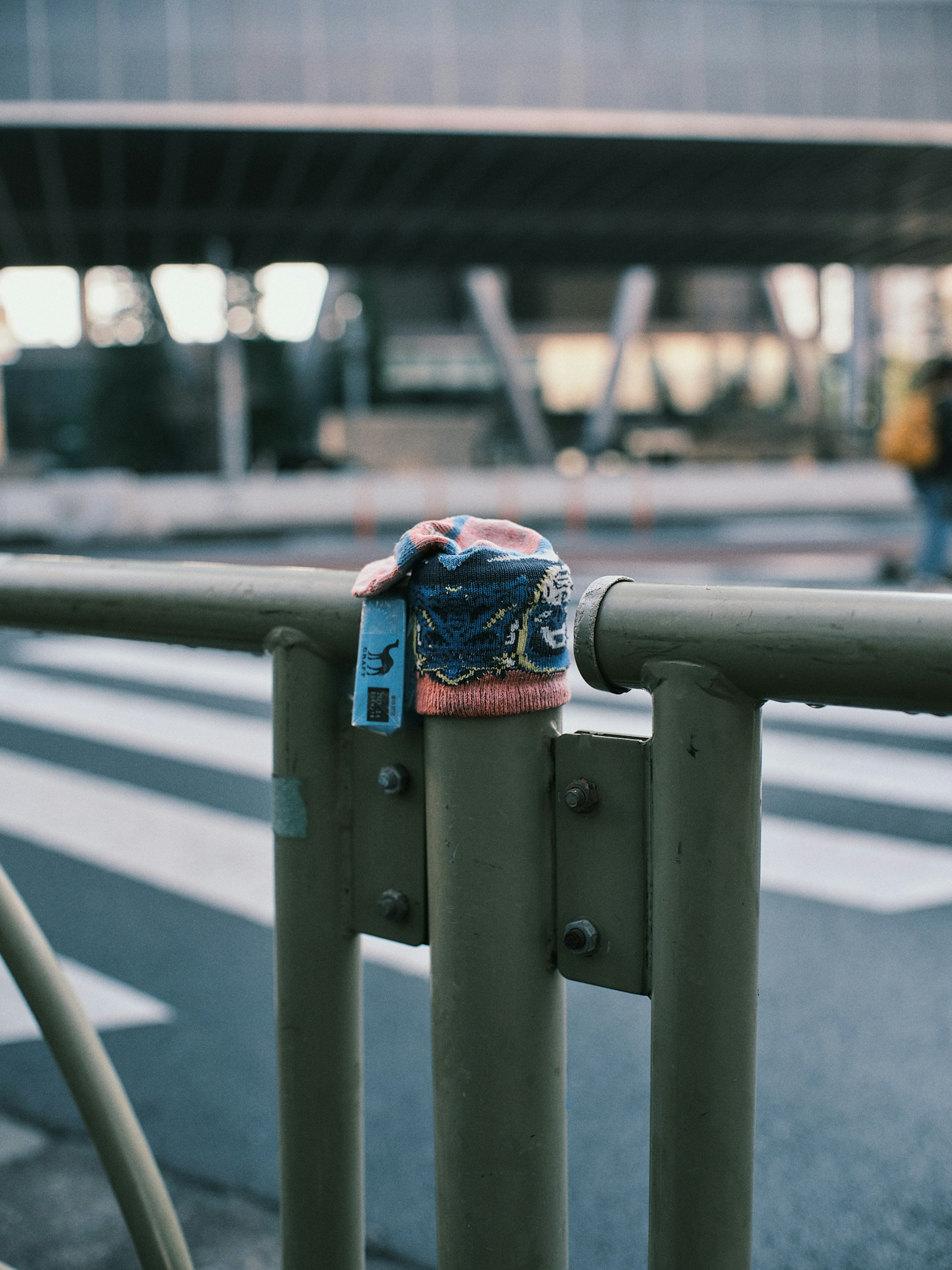 Colorful lock attached to a metal railing with an urban backdrop