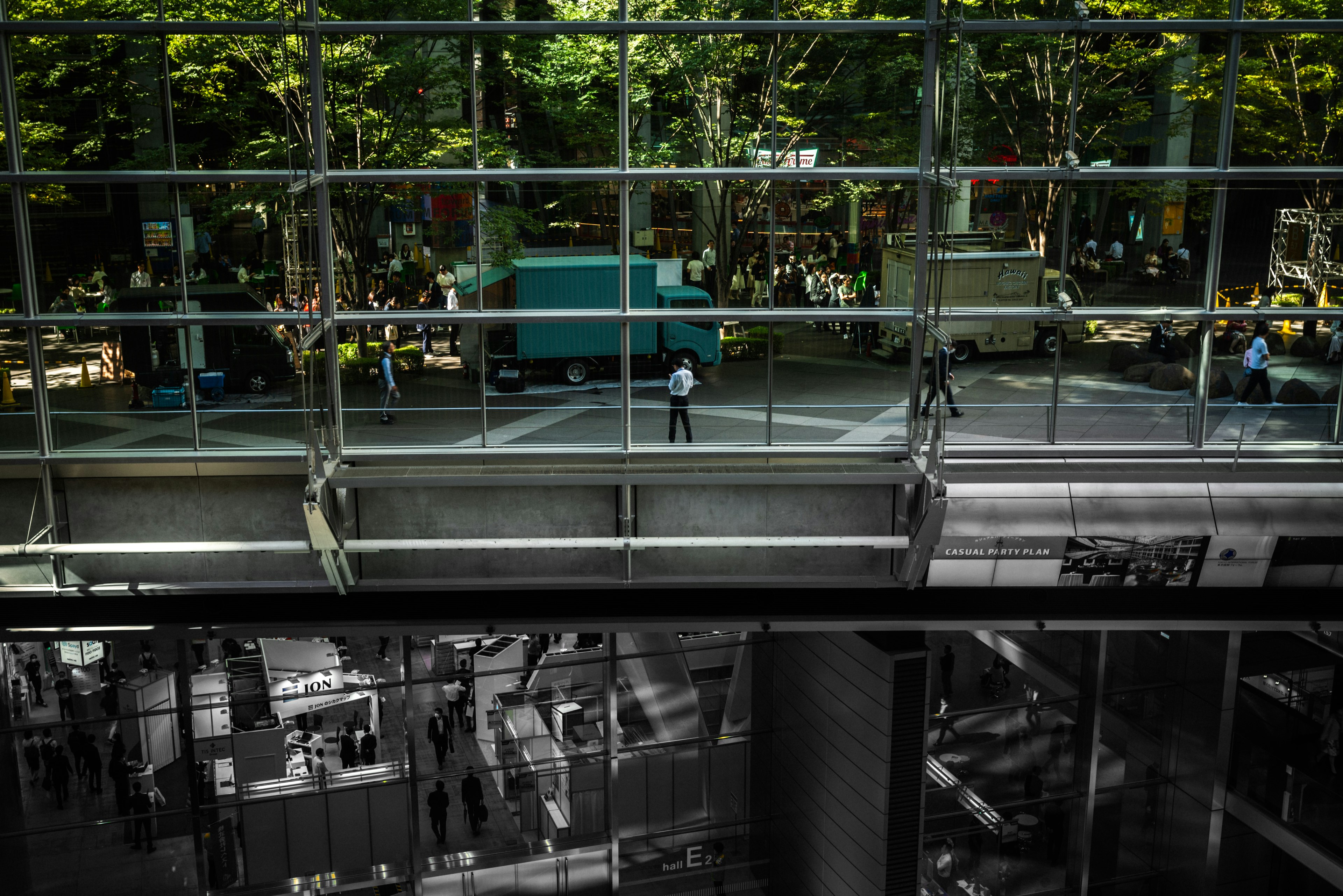 Vista di un parco e persone attraverso un muro di vetro moderno