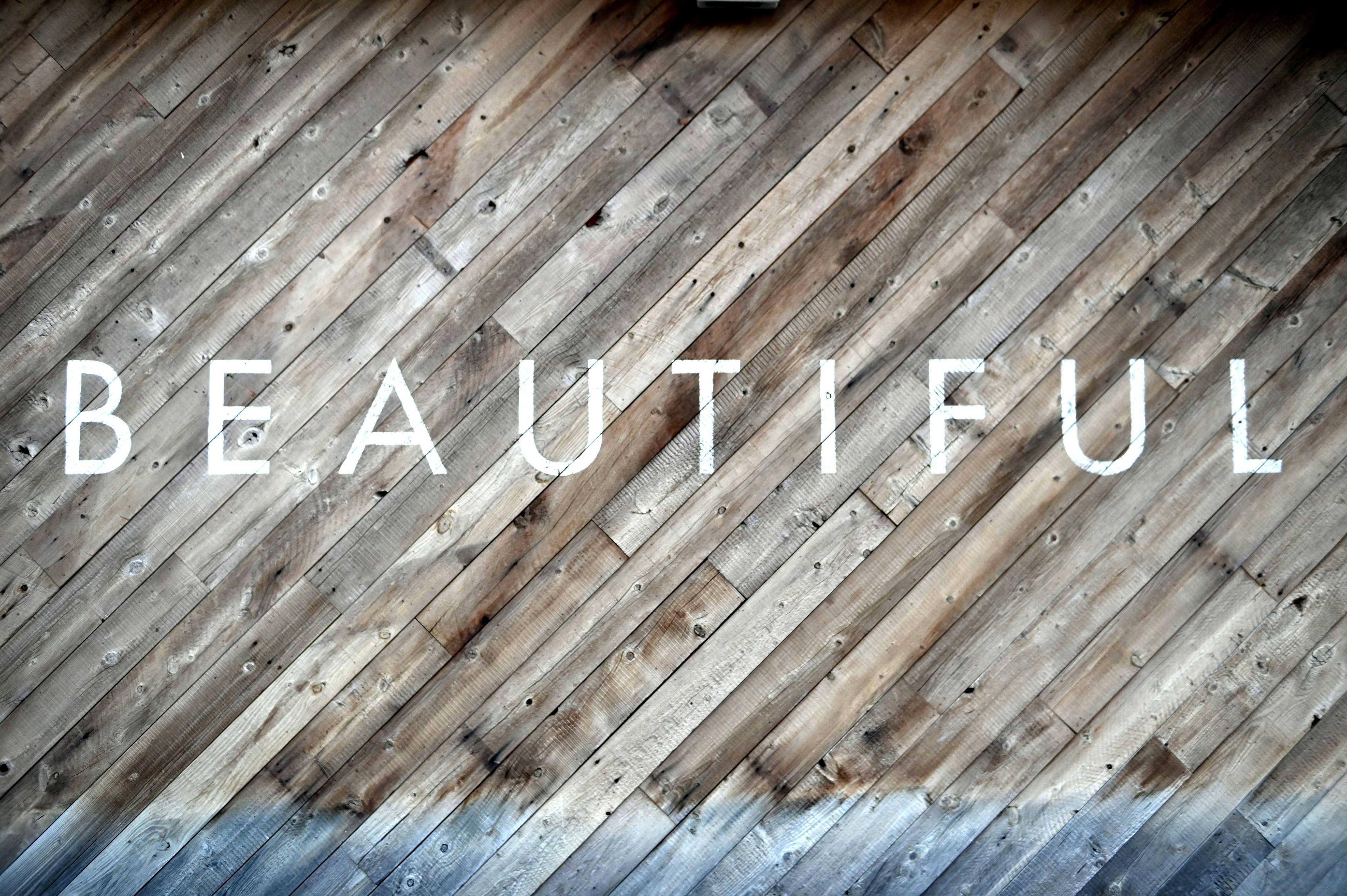 The word beautiful displayed on a wooden floor background