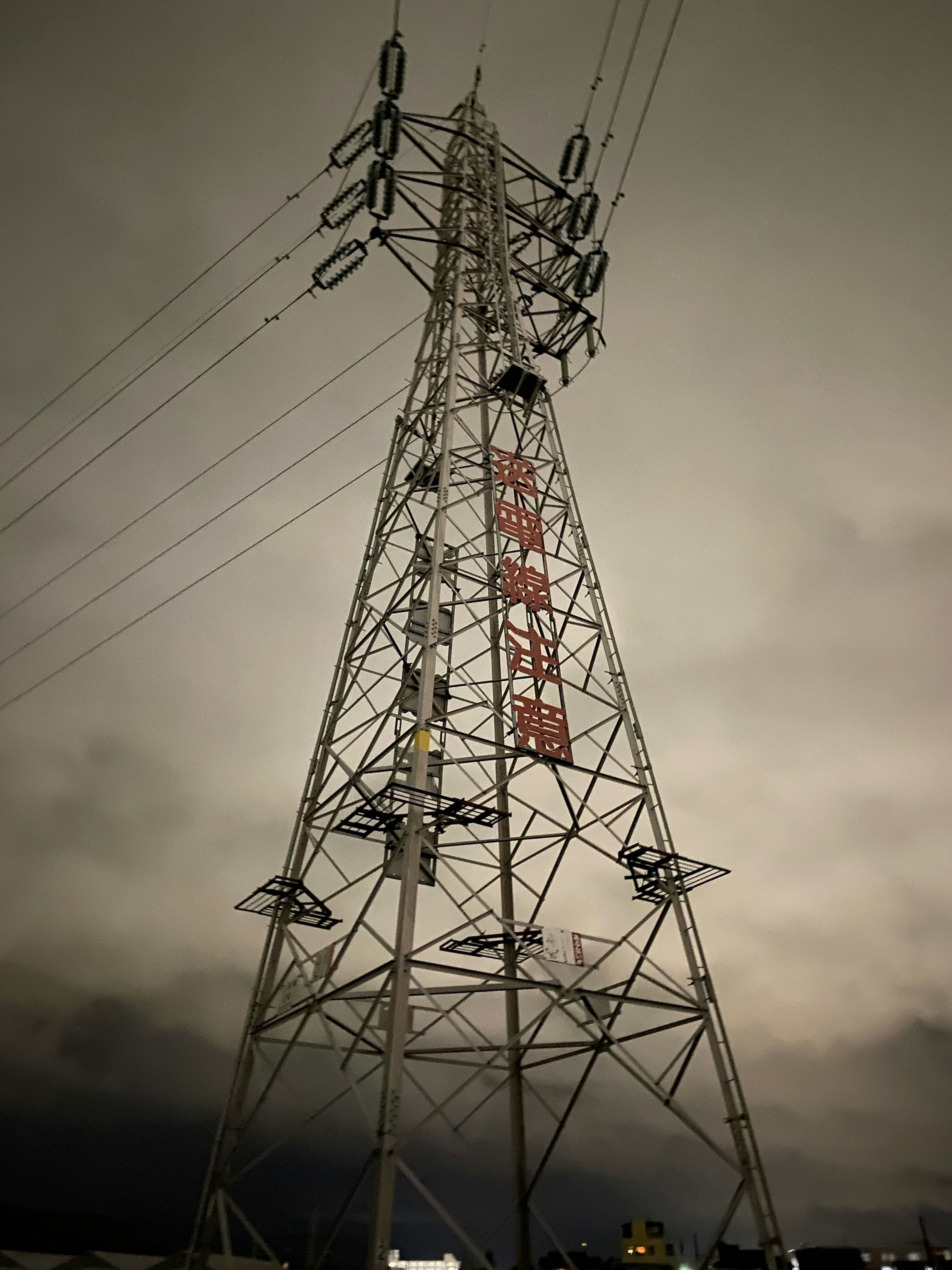 高圧電線の鉄塔が暗い空にそびえ立つ