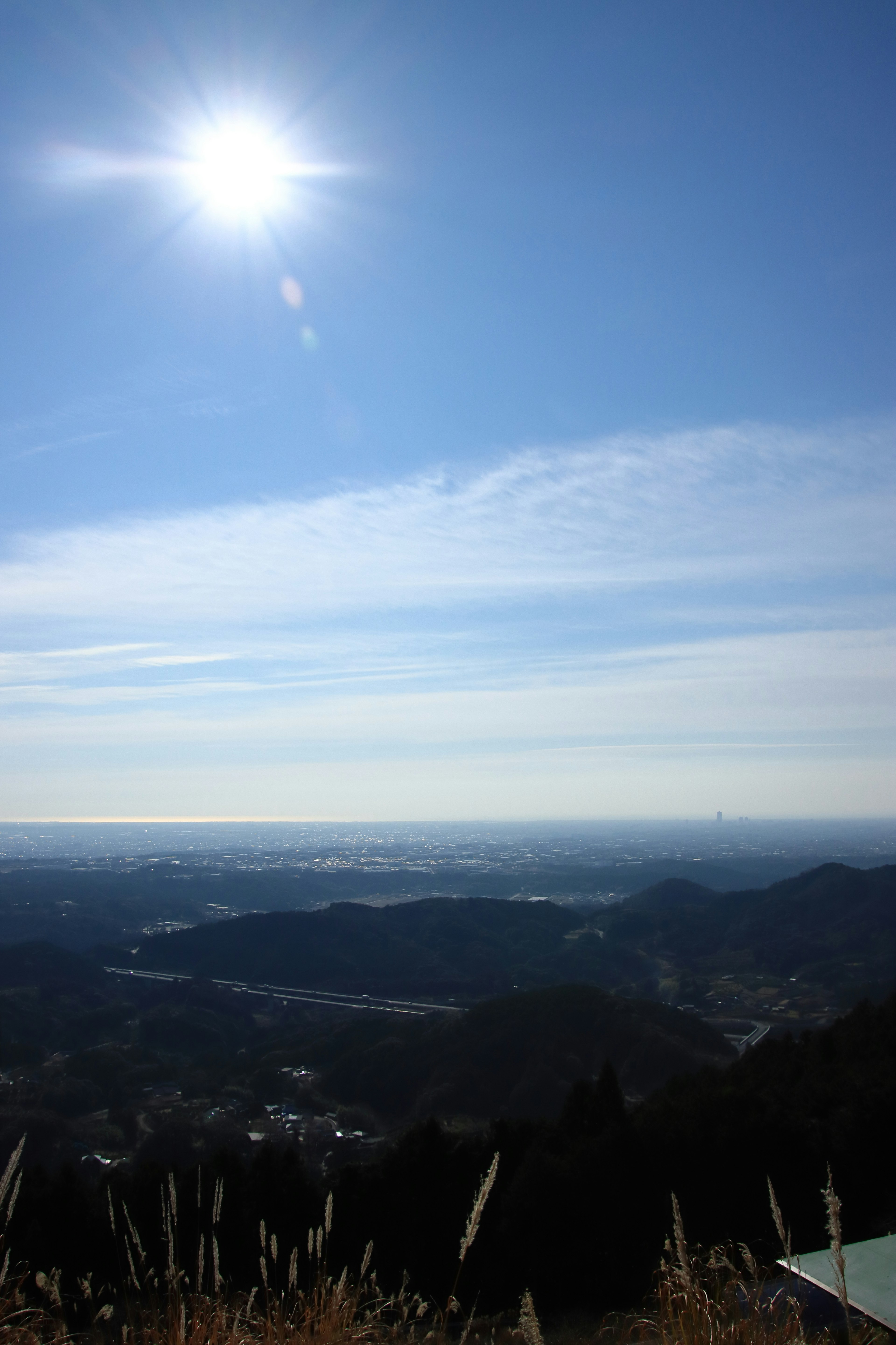 Bright sun shining over a vast landscape of mountains and valleys