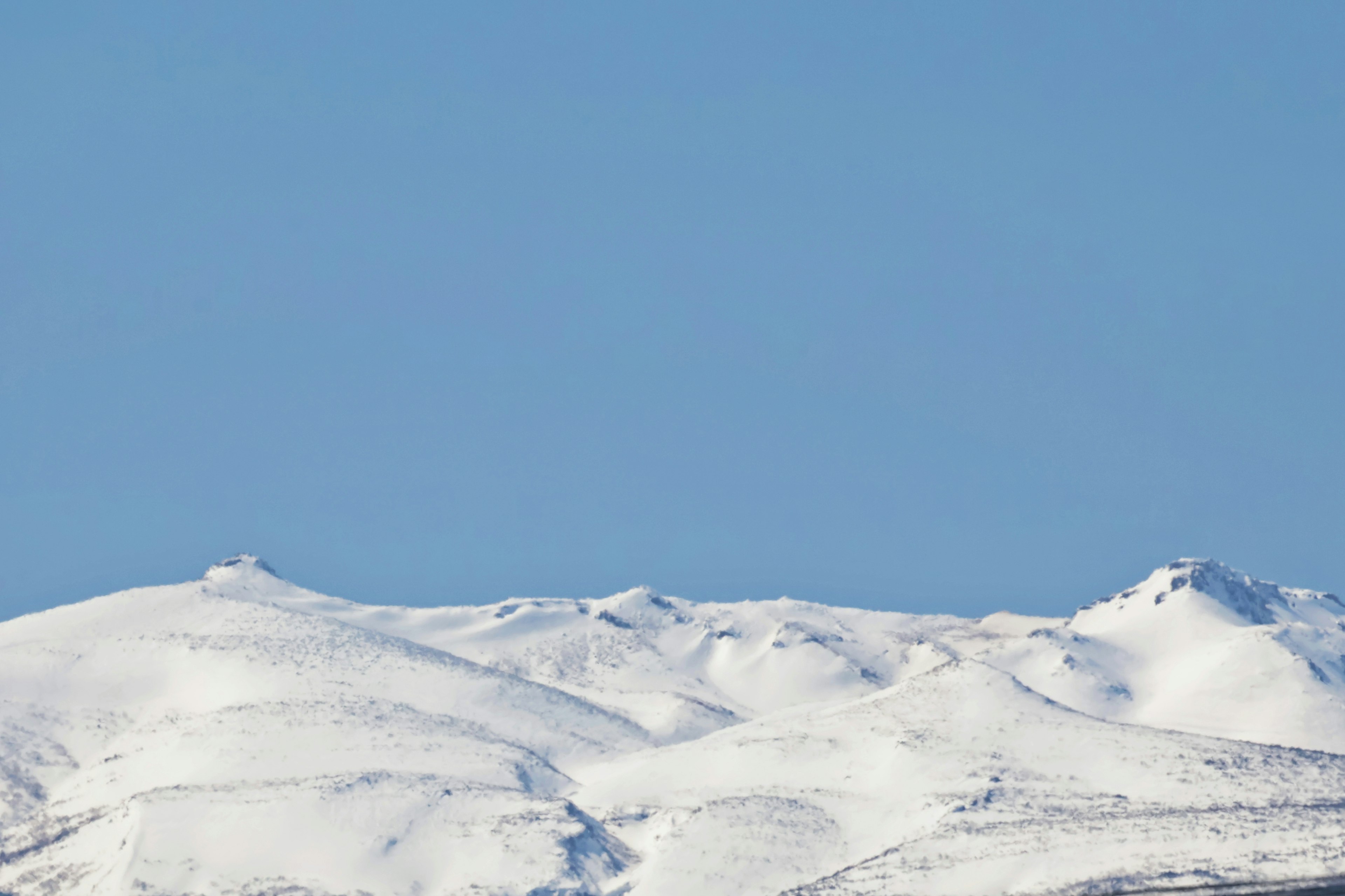 雪に覆われた山々と青い空