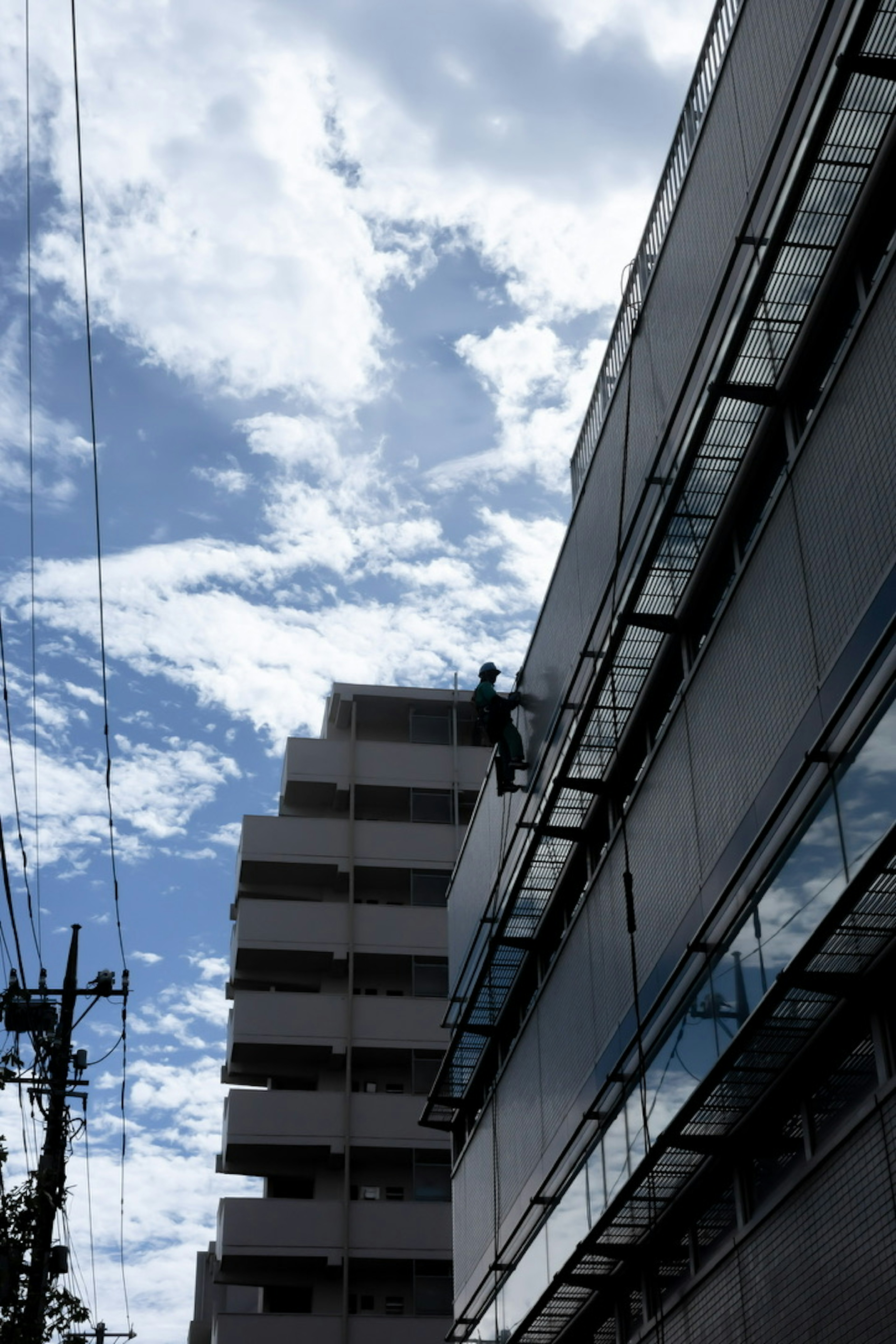 Arbeiter an der Außenseite eines Gebäudes mit blauem Himmel