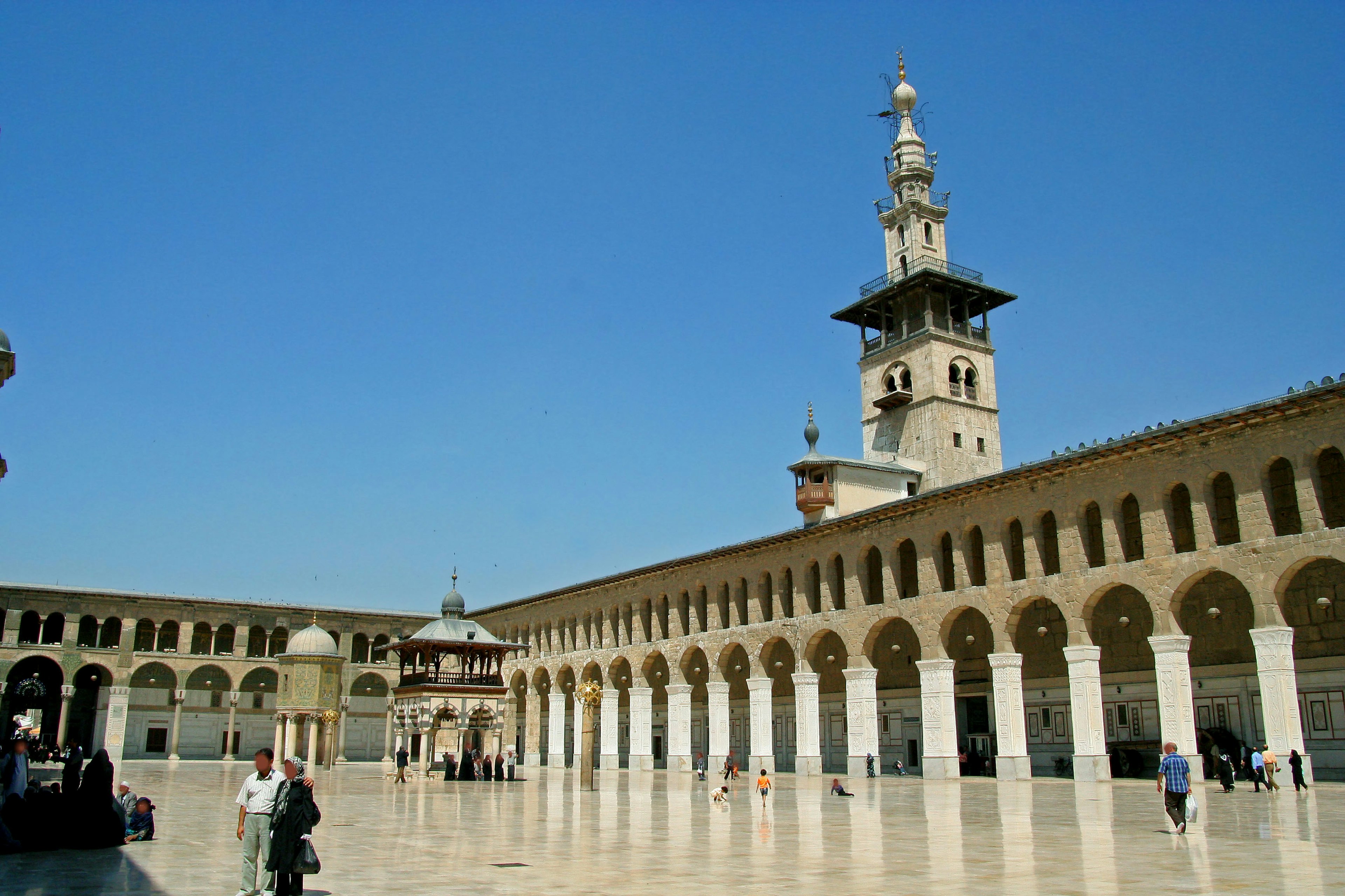 Grand mosque courtyard with a tall minaret