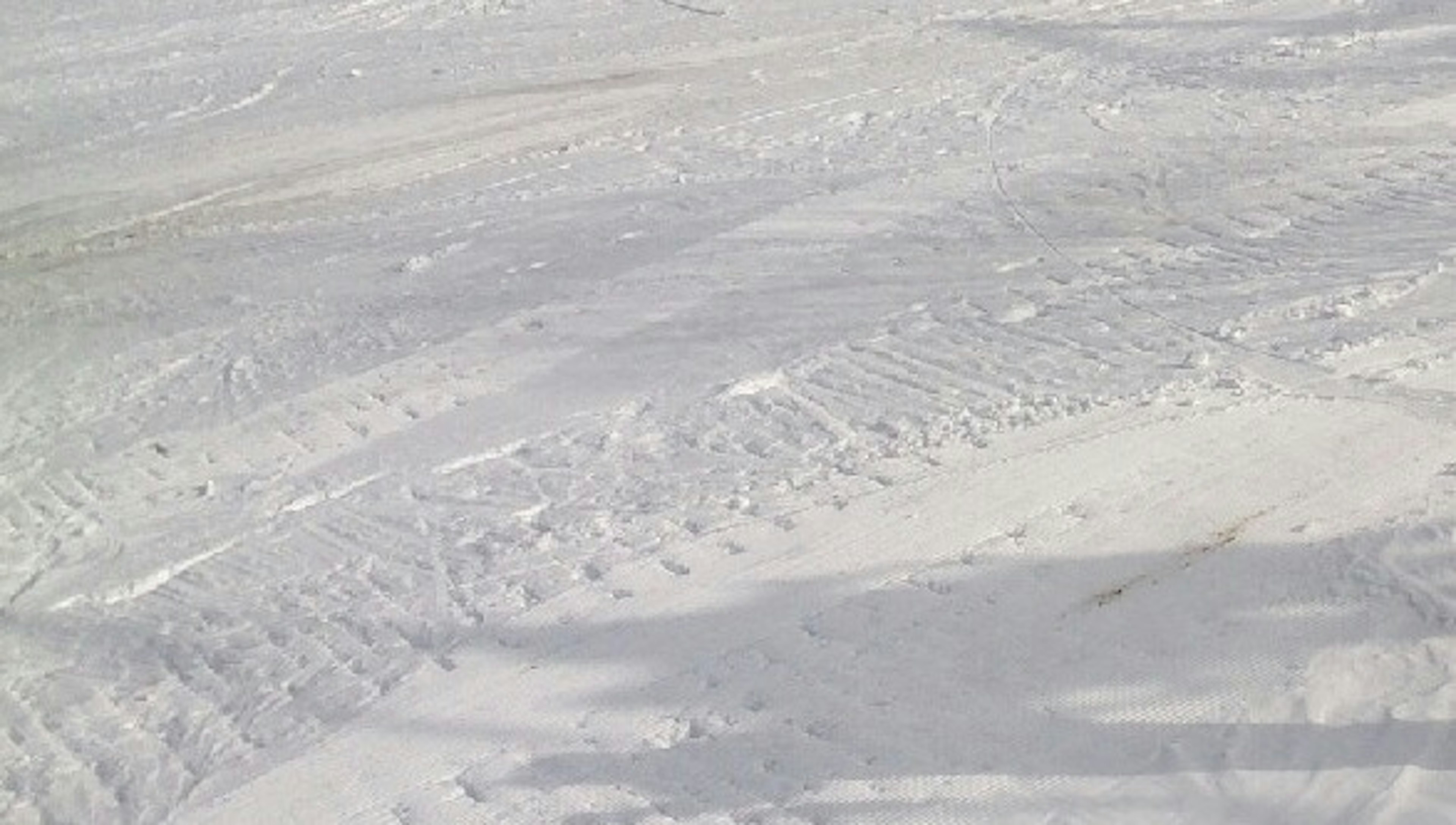 Textured snowy ground with visible tire tracks