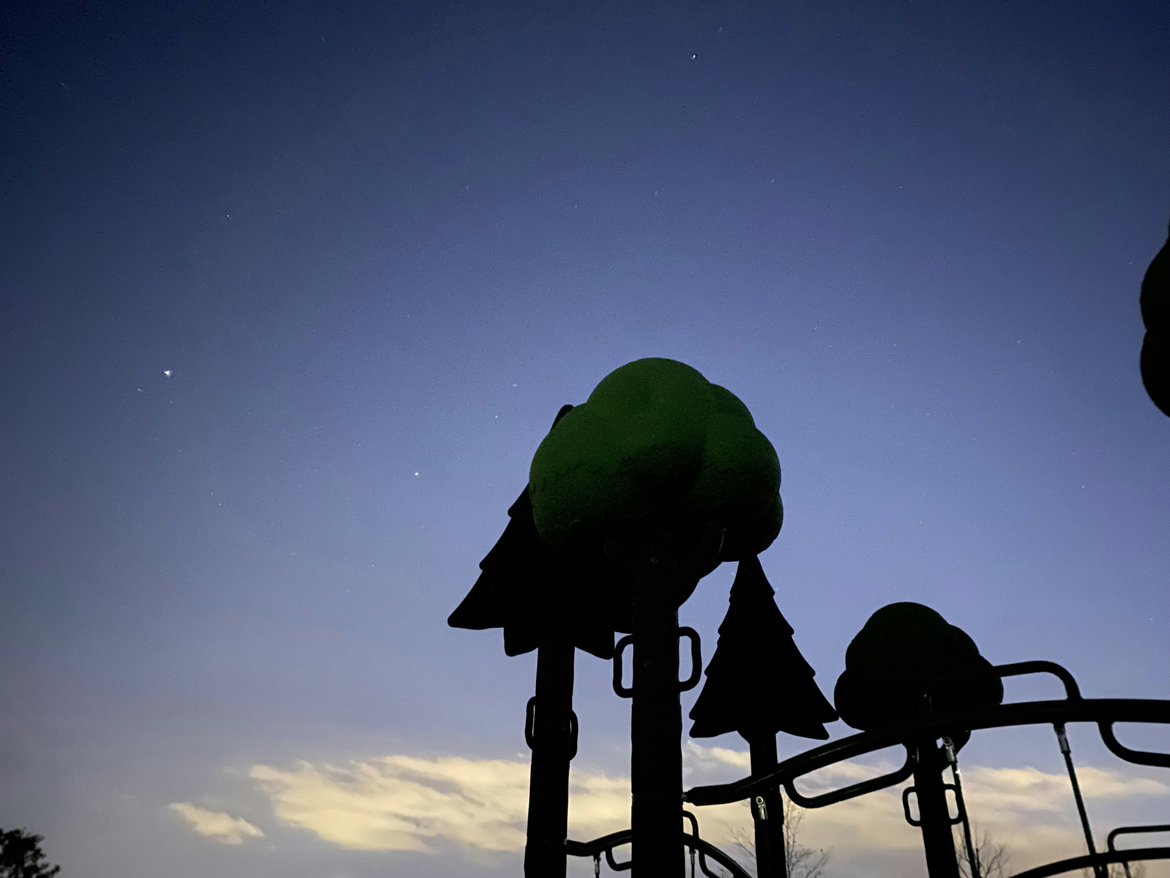 Silhouette de equipo de parque infantil contra un cielo crepuscular