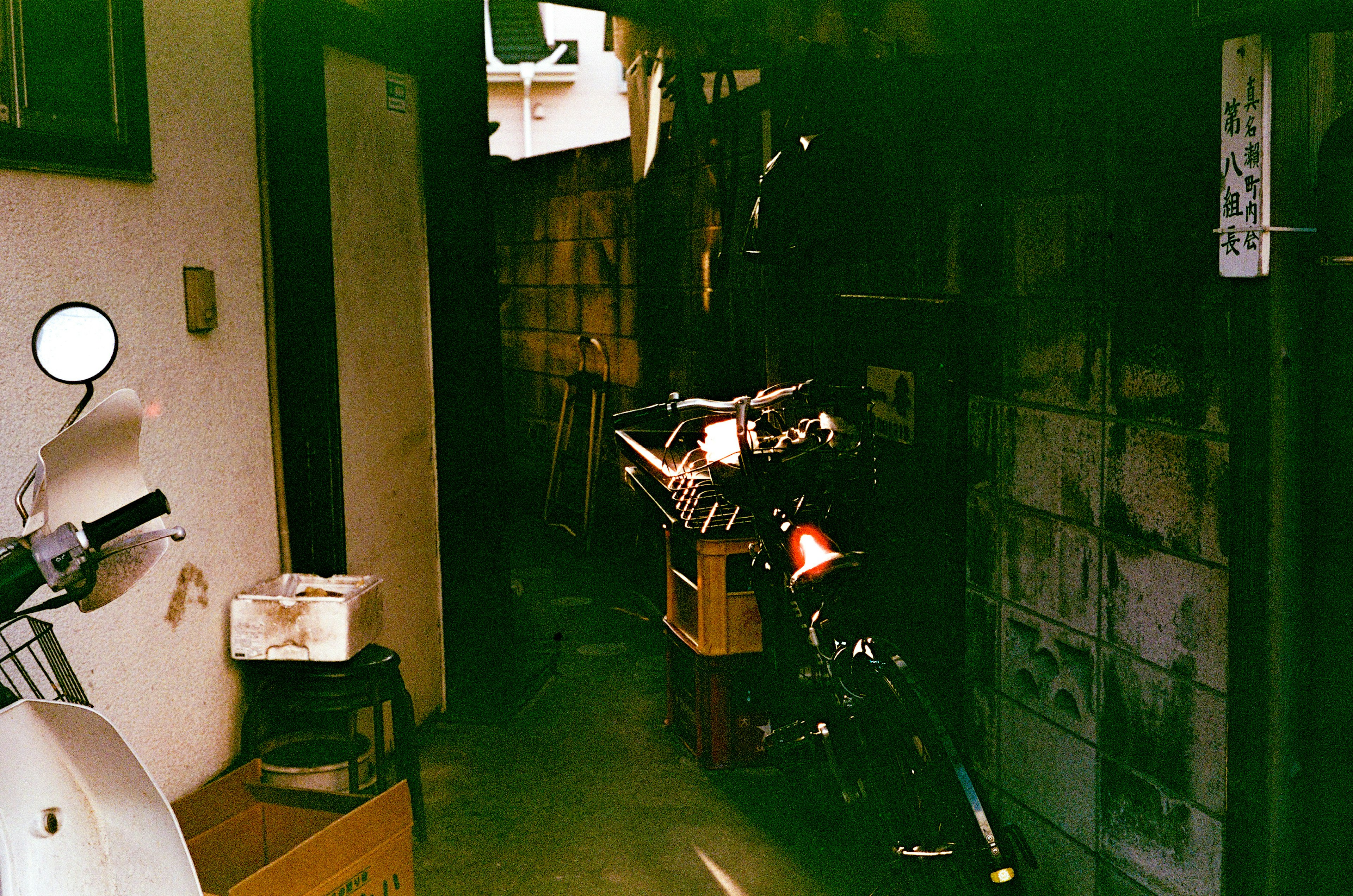 Narrow passageway with a motorcycle and surrounding items