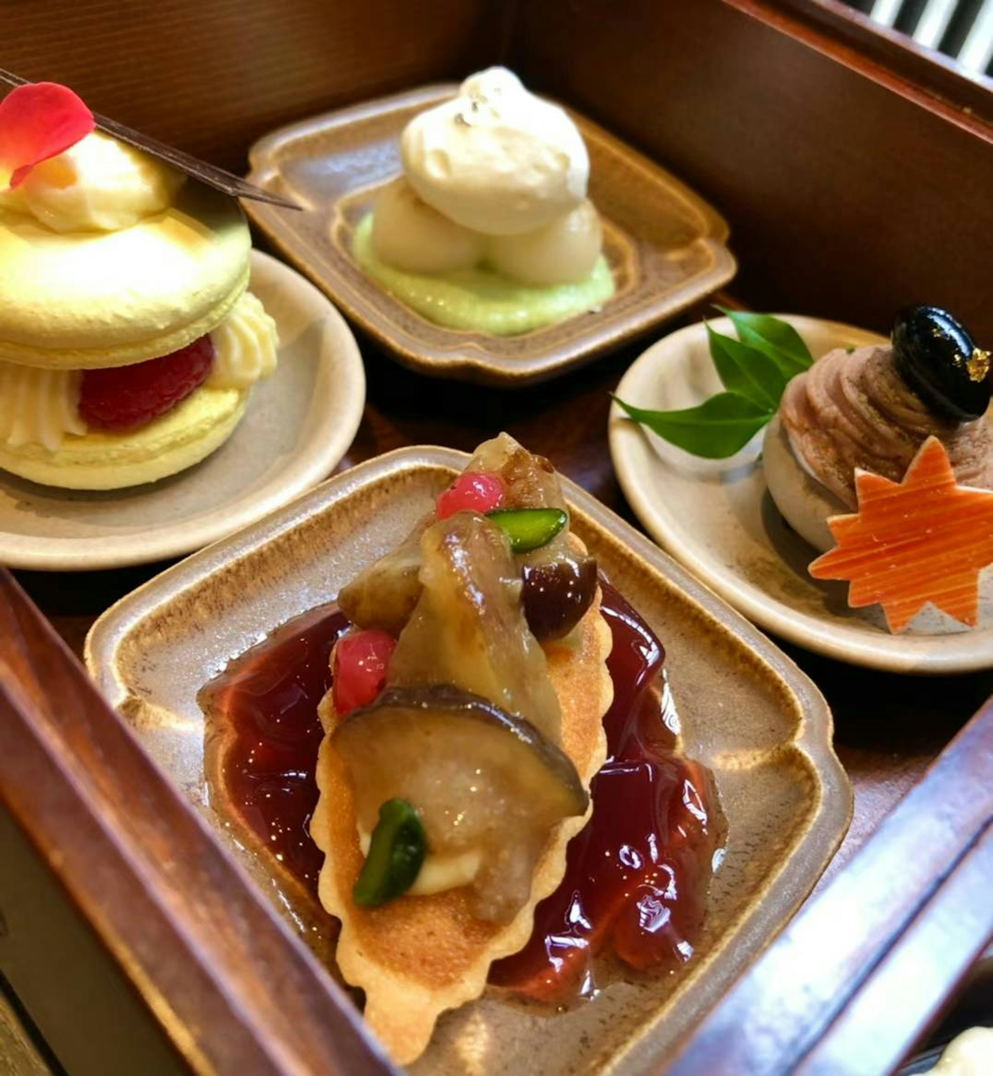 A wooden tray featuring an assortment of traditional Japanese sweets with vibrant colors and intricate designs