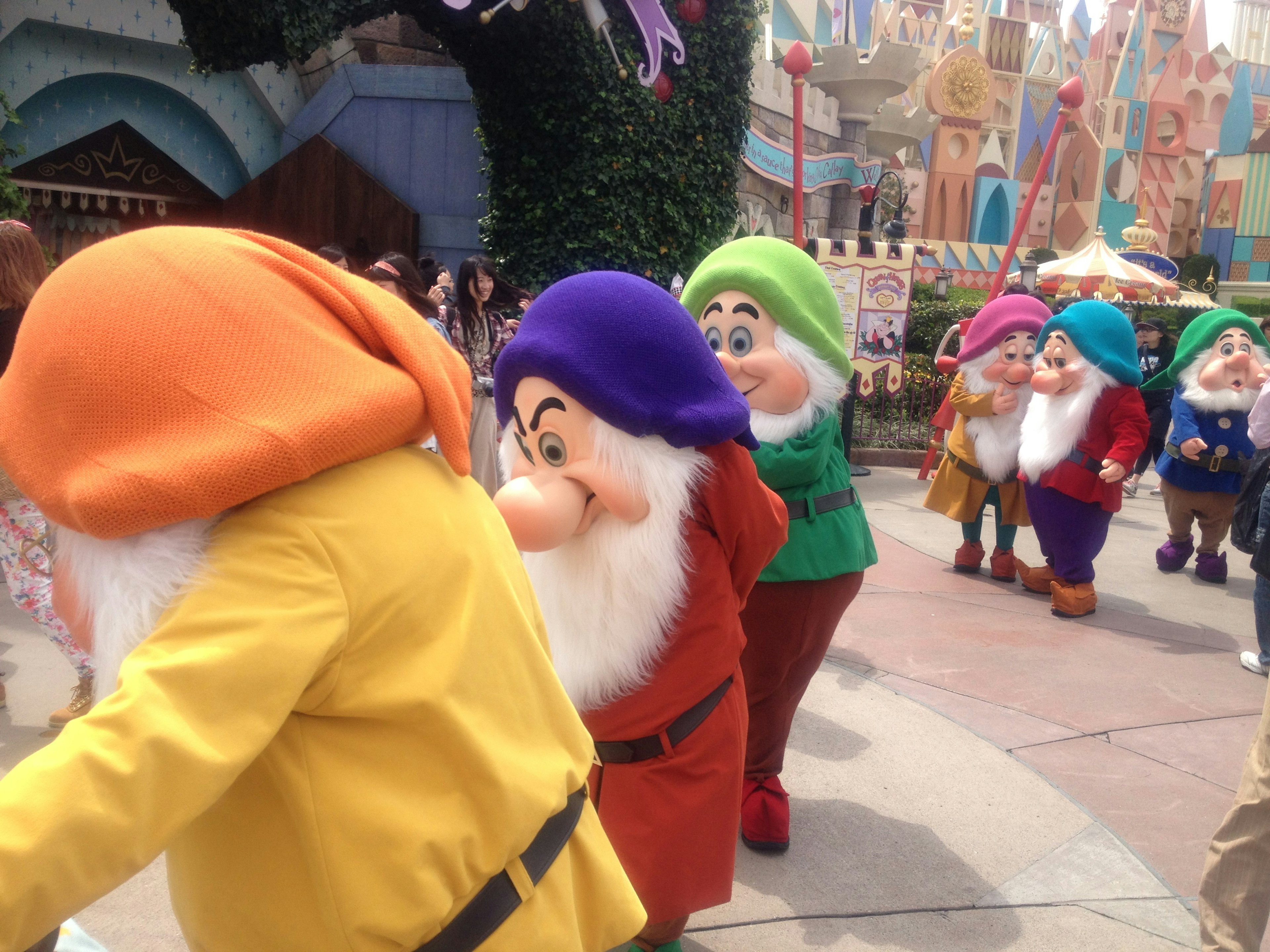 Dwarfs from Disney theme park parading in colorful costumes