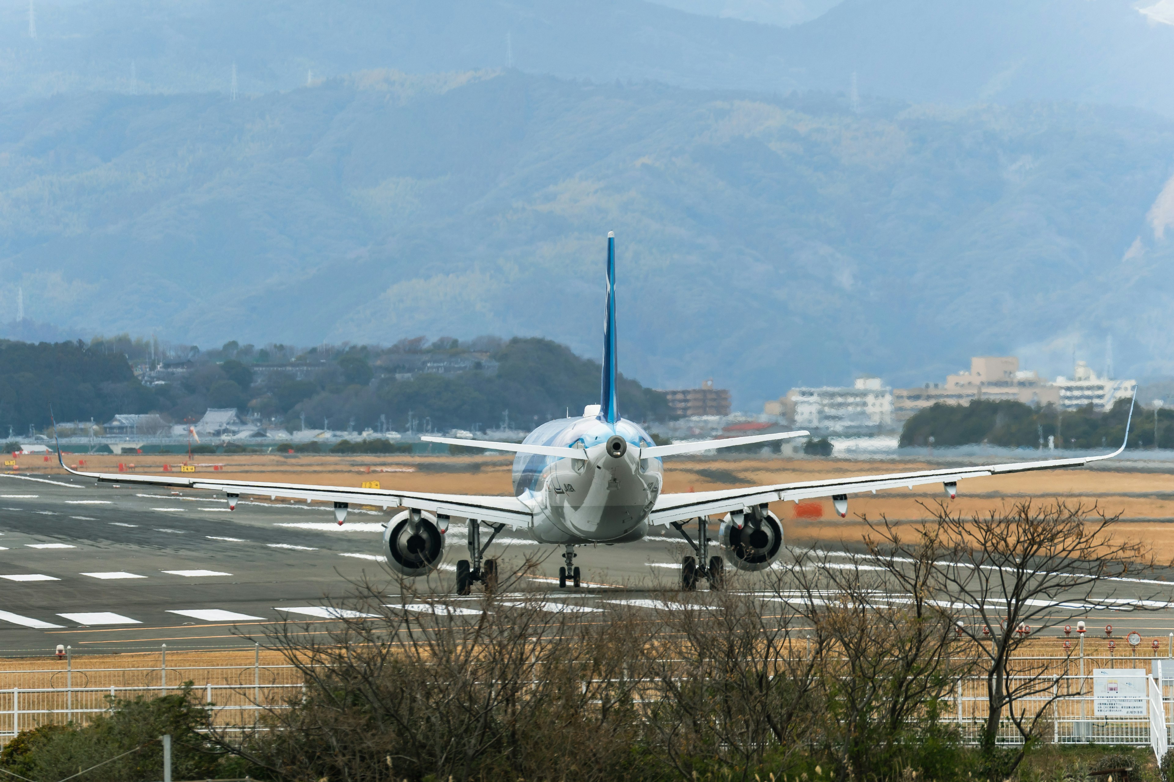 滑走路に向かって進む航空機の後ろ姿