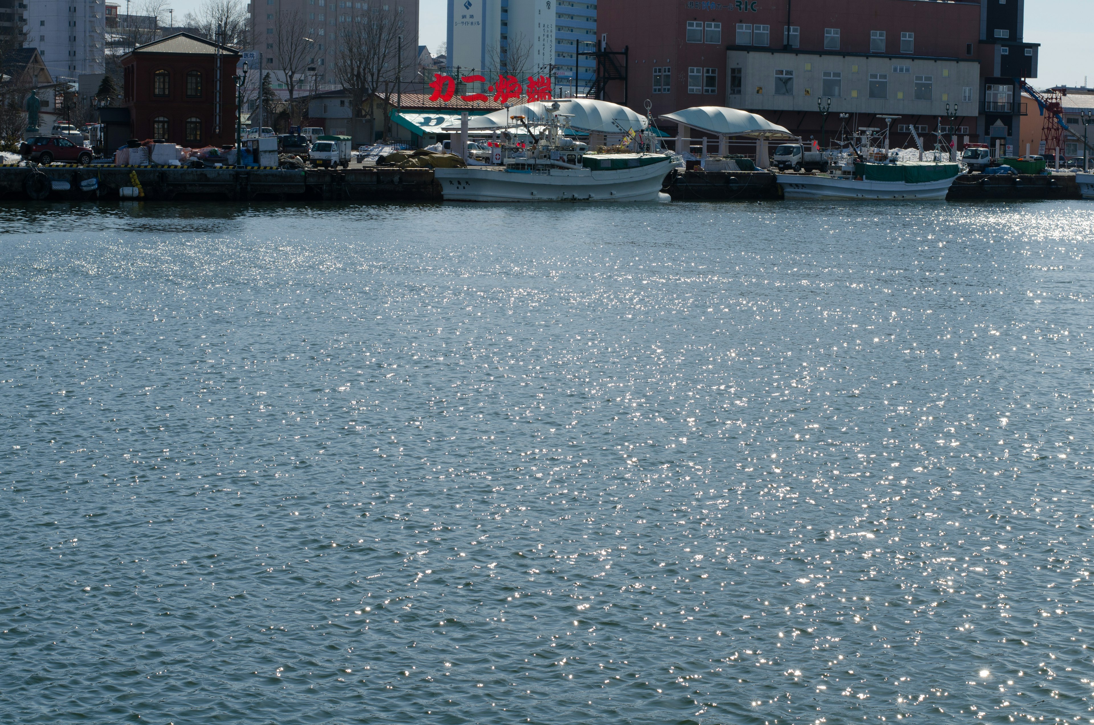 Scène de port avec des bateaux et une surface d'eau scintillante