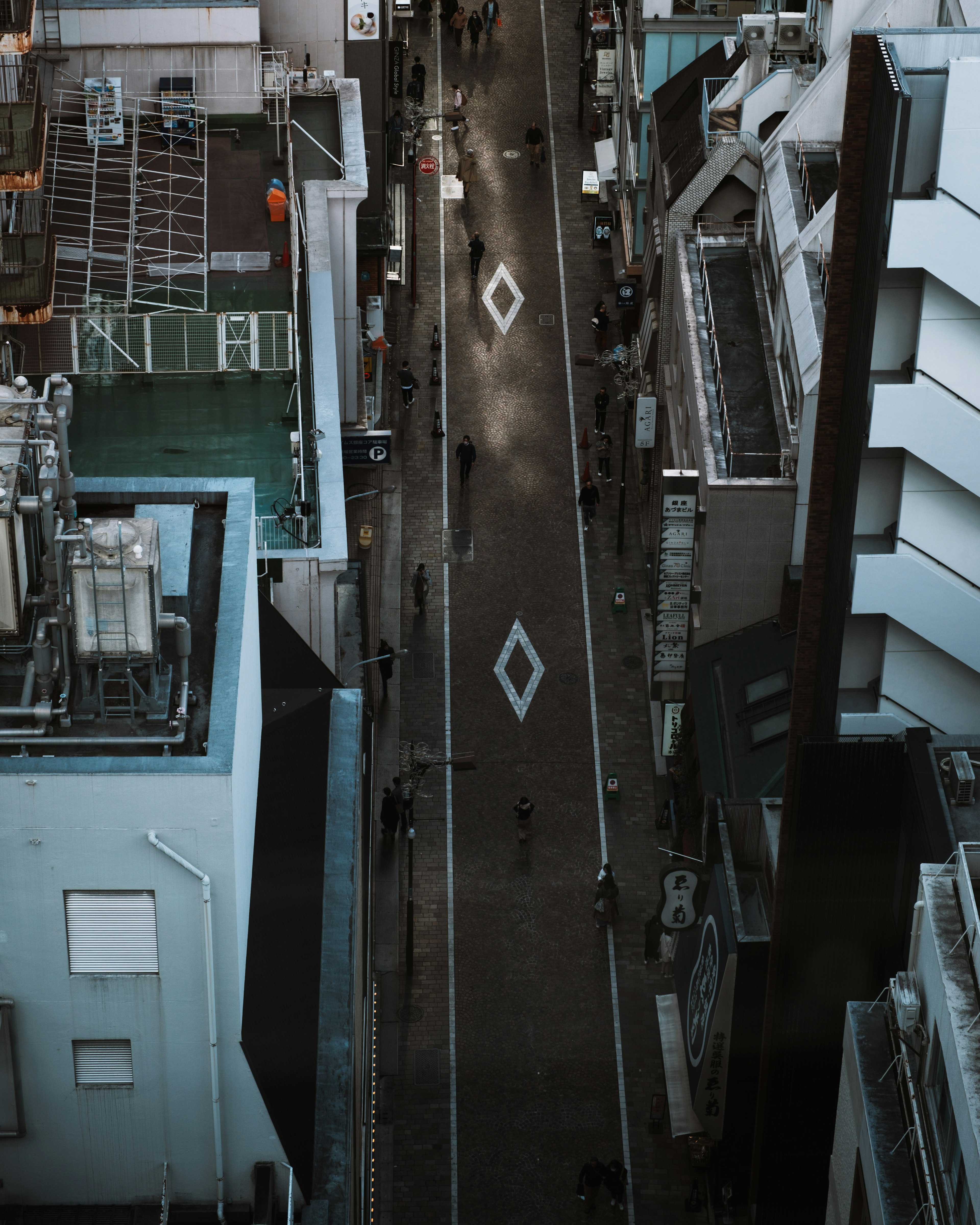 Aerial view of a city street with buildings lined up and diamond patterns on the pavement