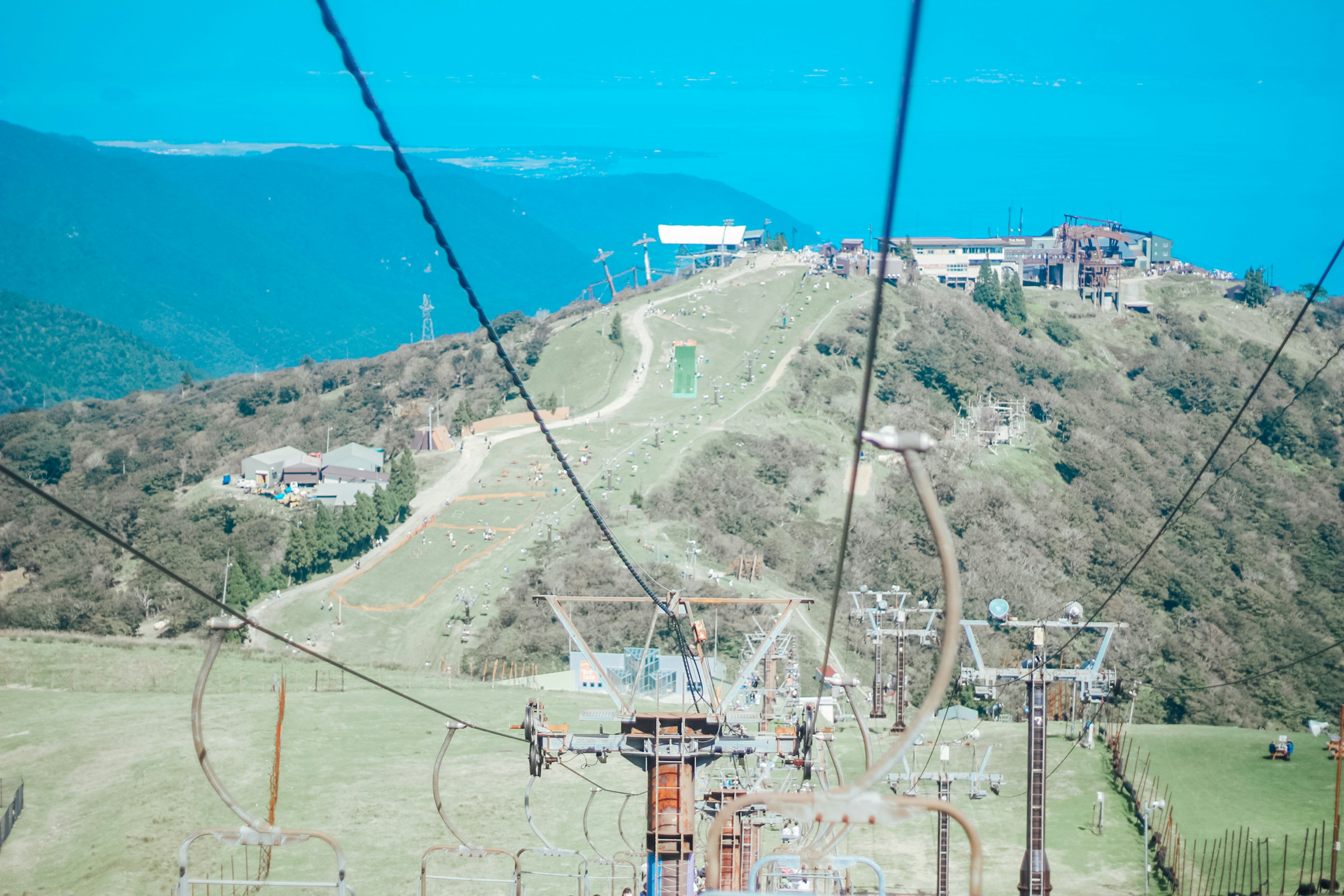 Pemandangan gunung di bawah langit biru dengan kabel lift ski