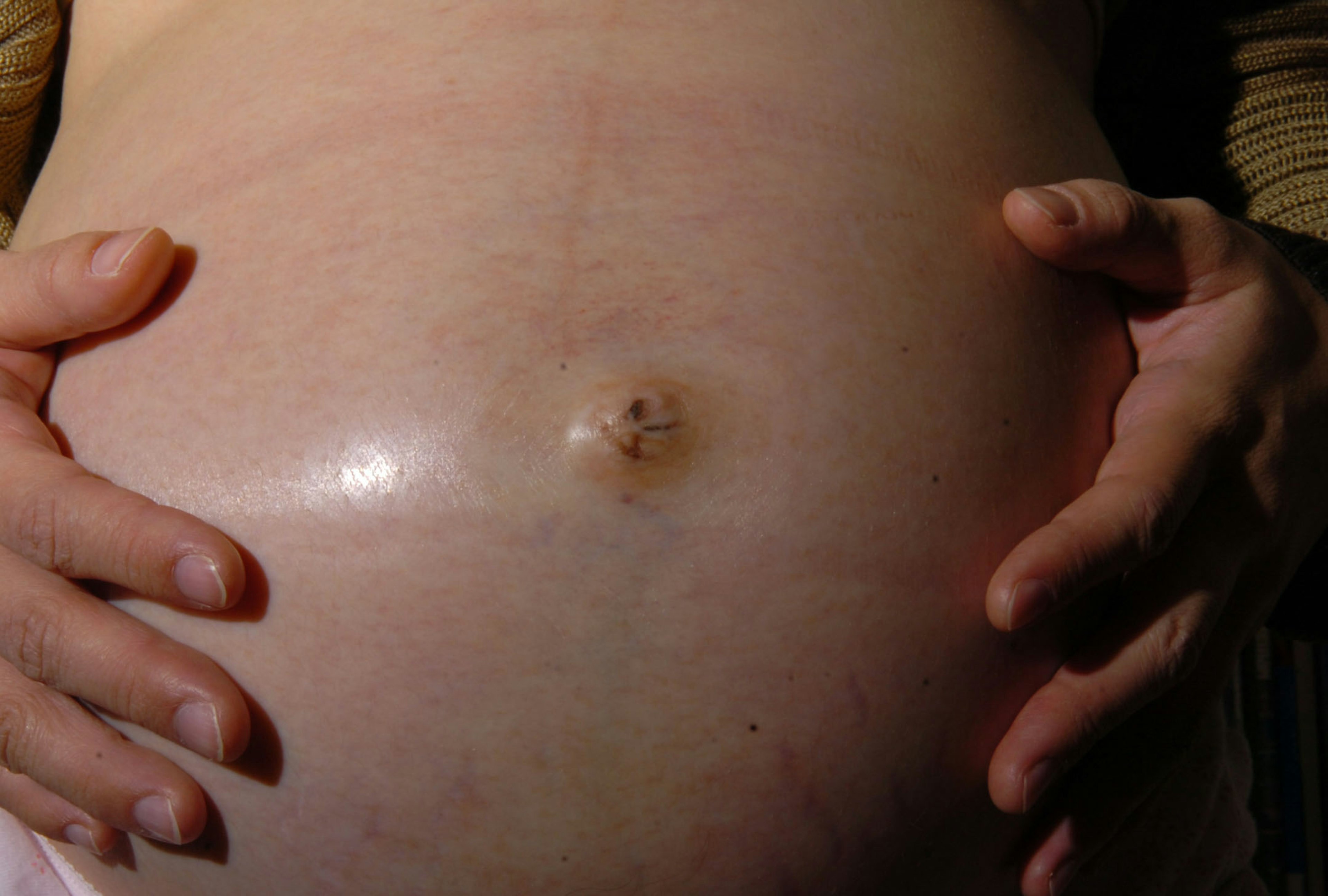 Abdomen d'une femme enceinte avec des mains