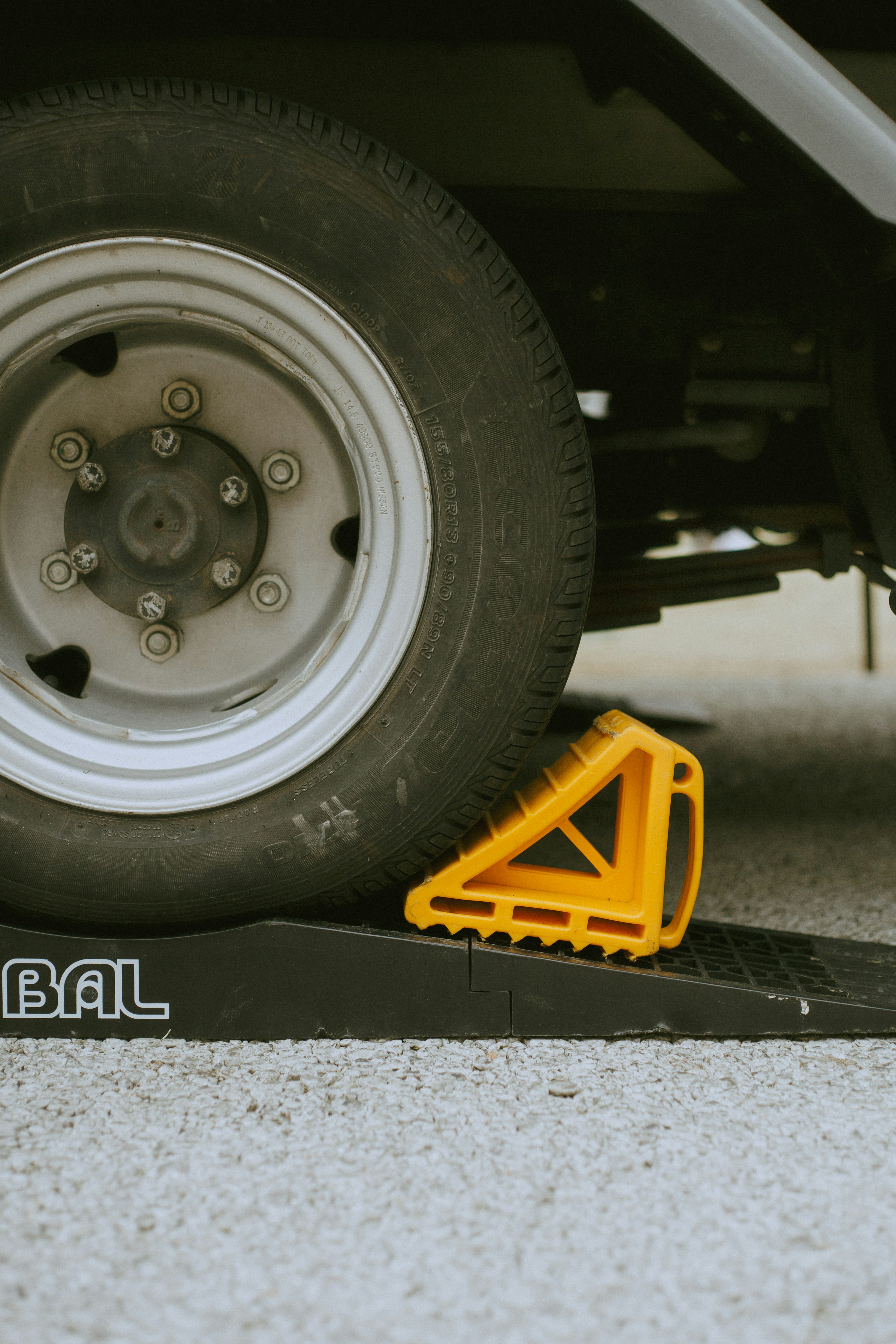 Yellow wheel chock under a tire with a black base