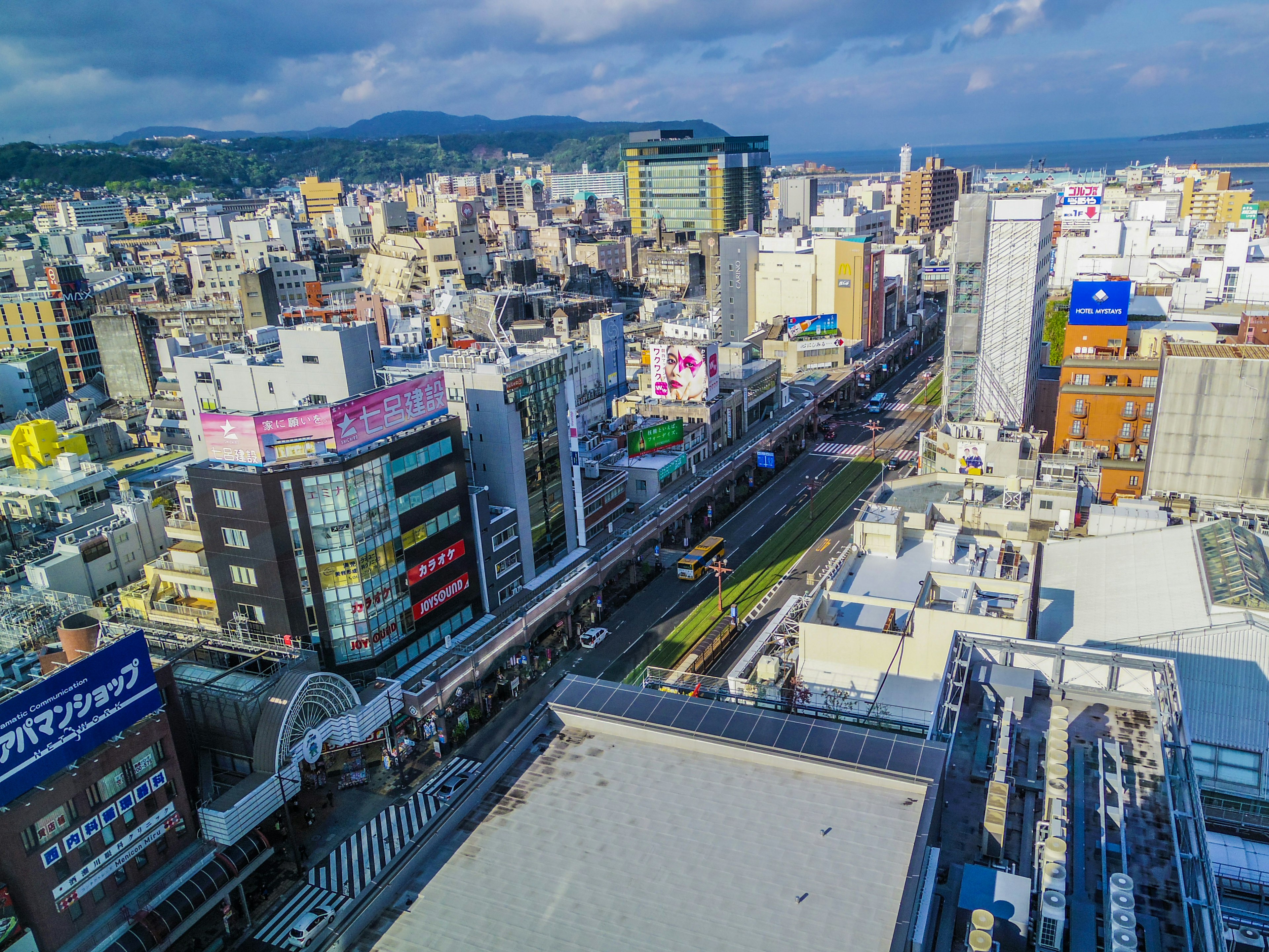 Panoramic view of skyscrapers and bustling city streets with visible ocean in the background