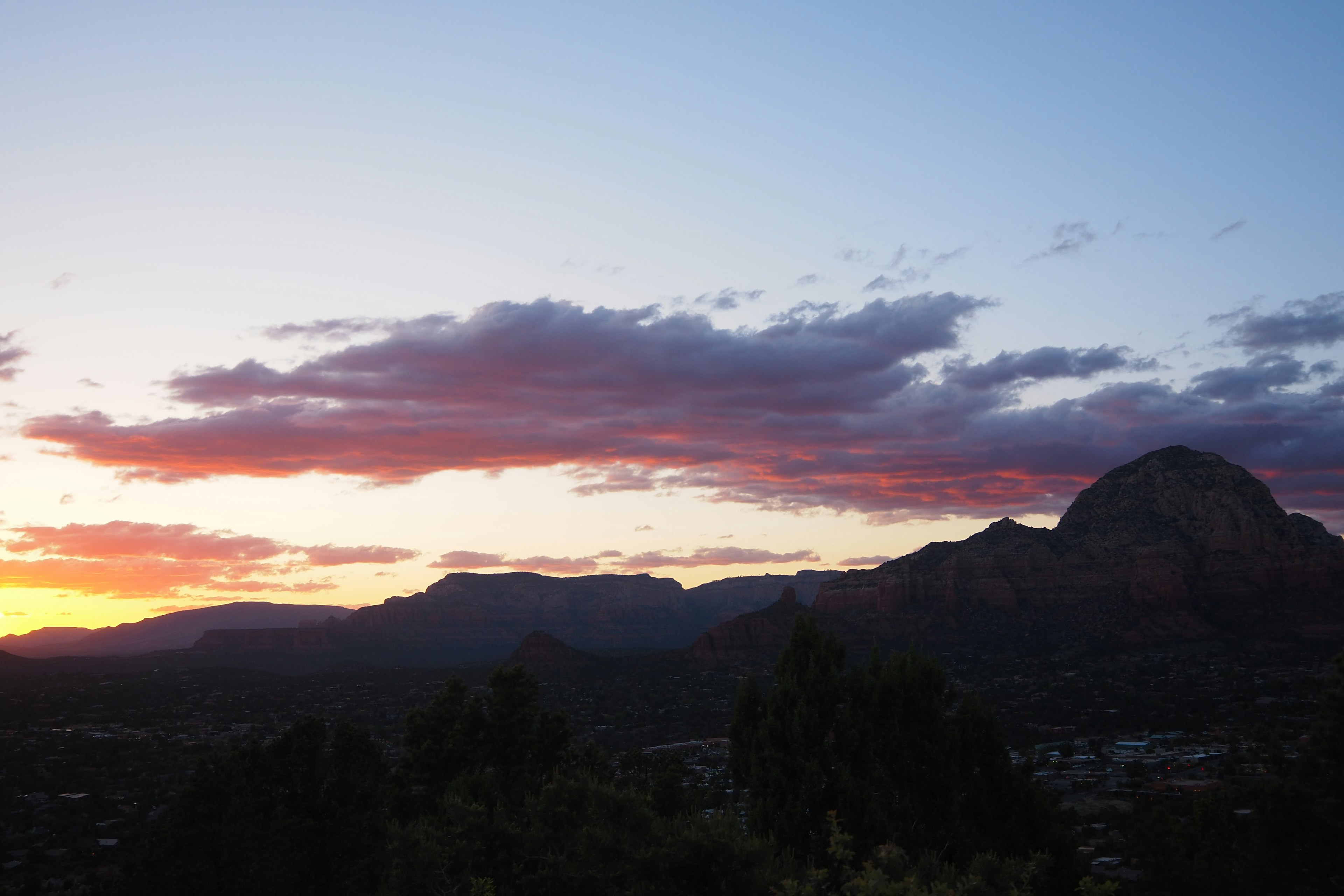 Vista drammatica del tramonto con montagne e nuvole colorate