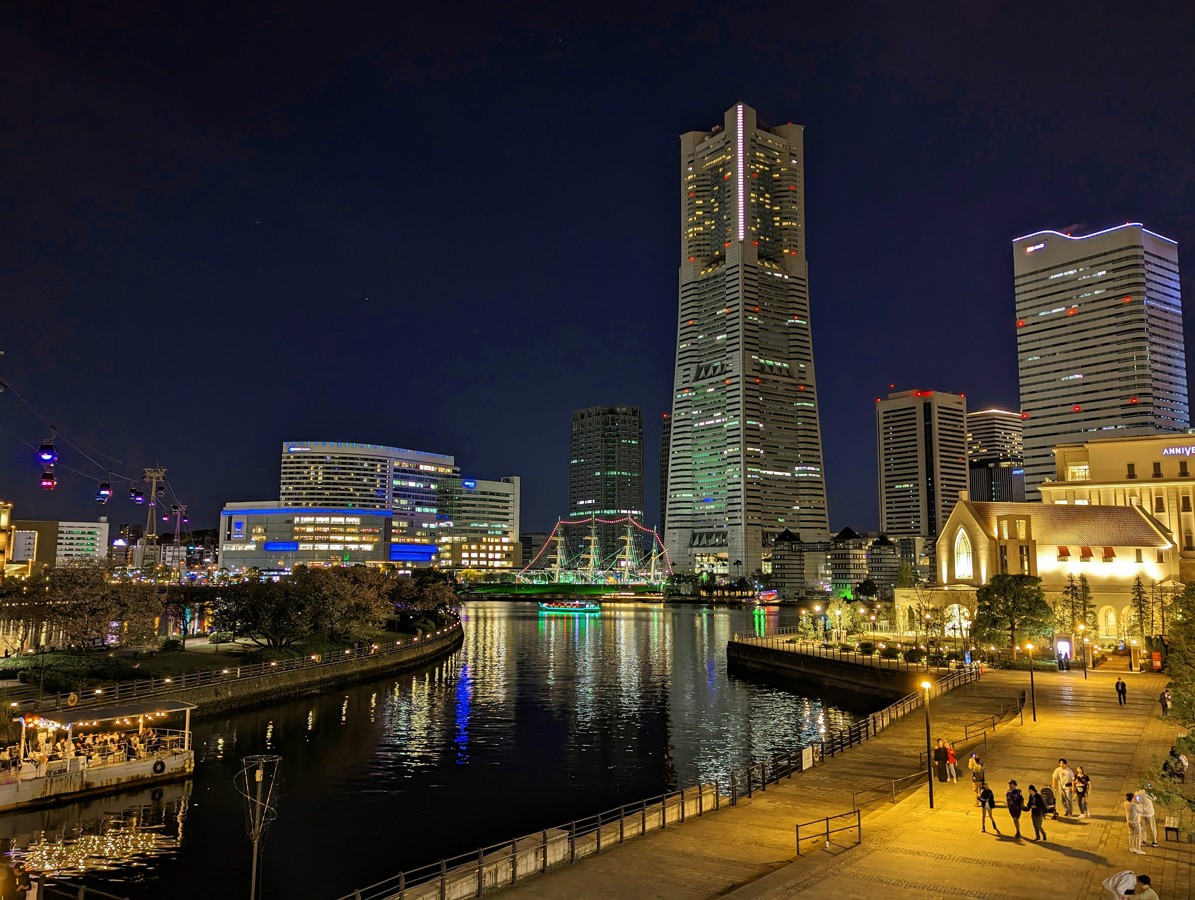 Vista nocturna del horizonte de Yokohama con edificios iluminados y costa